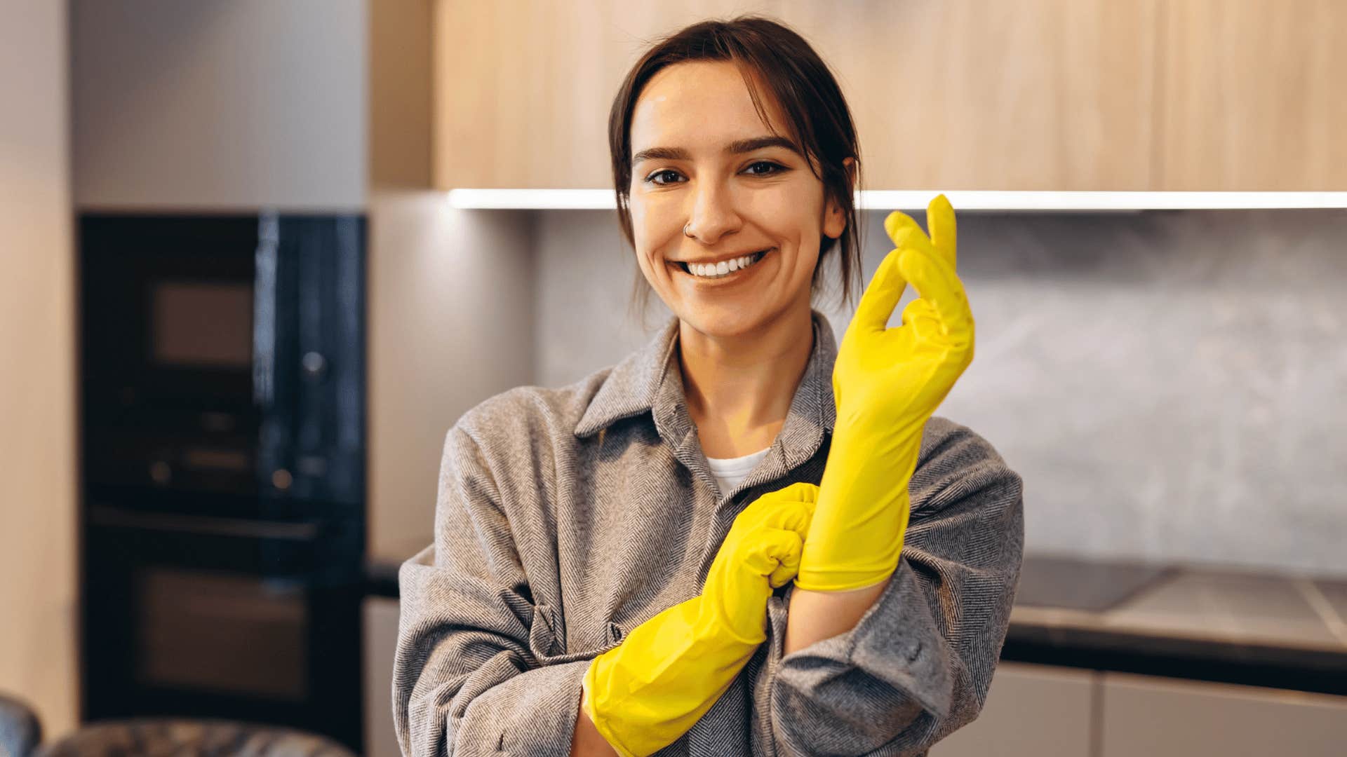 woman putting on rubber gloves to deep clean her home
