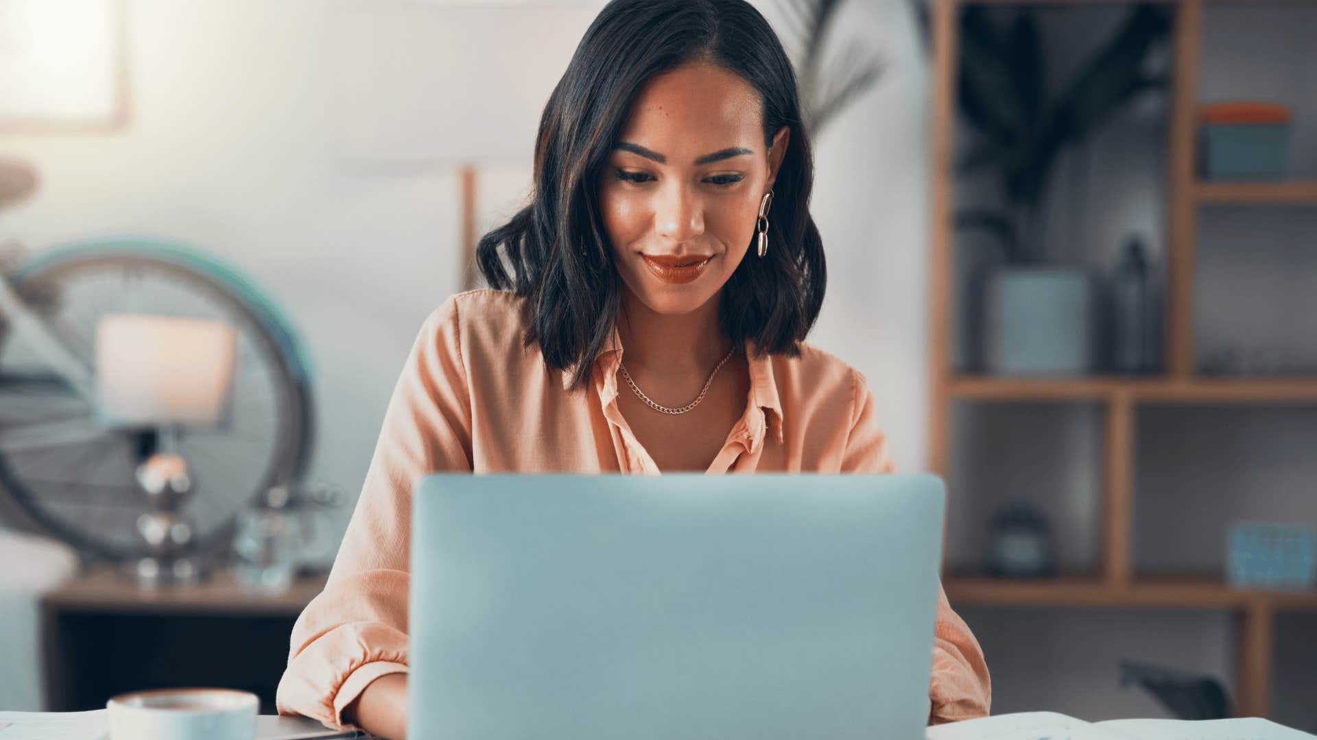 smiling professional woman updating her resume on computer