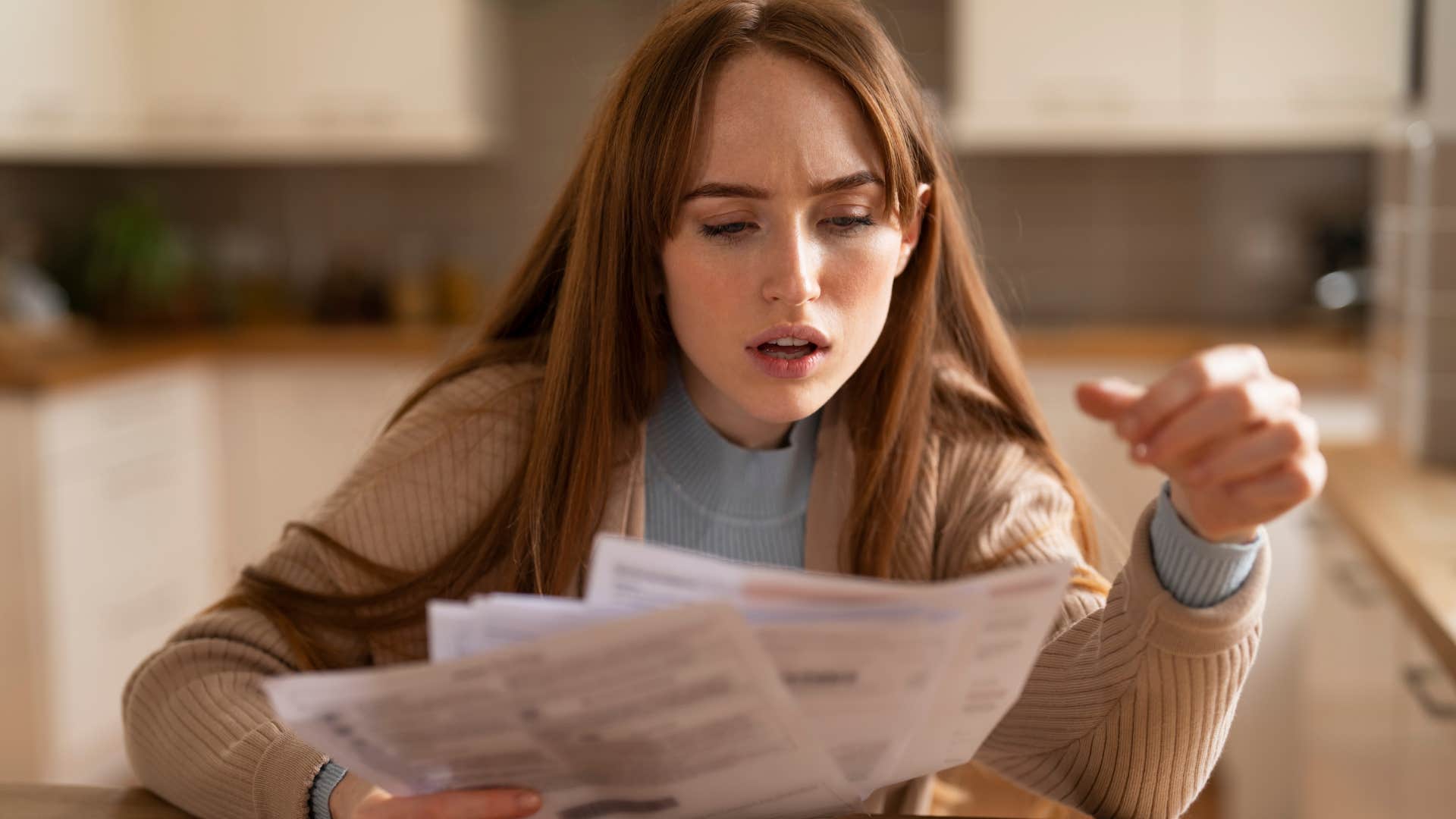 Shocked Gen Z woman doing bills and not saving money.