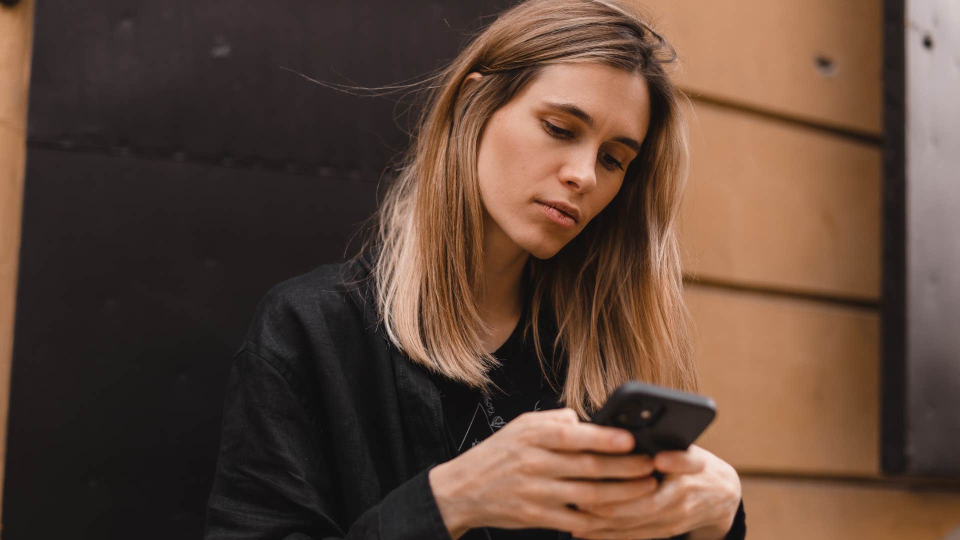 Woman looking at her phone and ignoring new social interactions.
