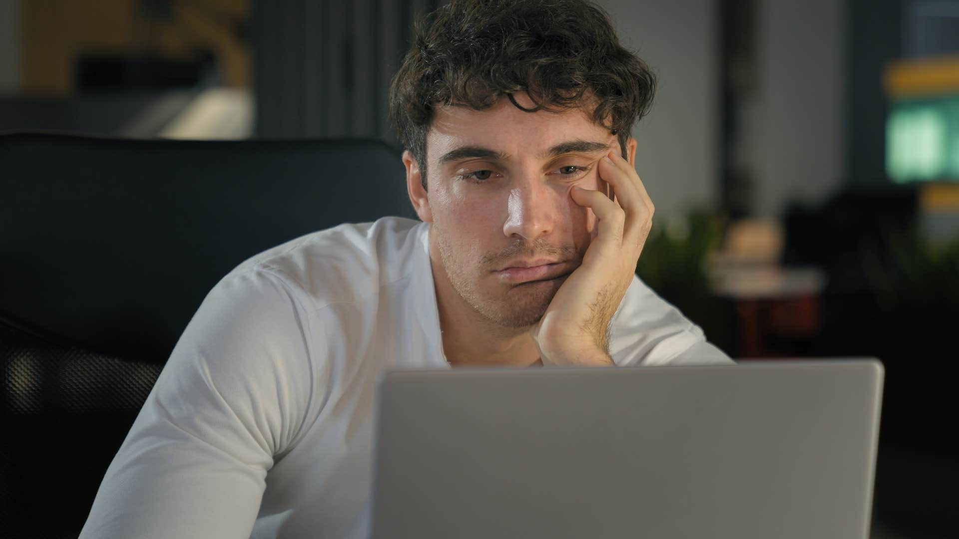 Man relying on unhealthy vices looking tired at work.