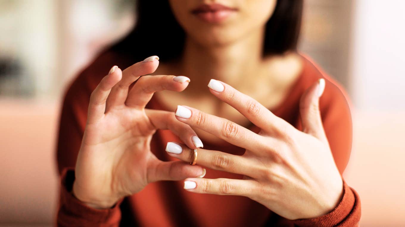 Married woman taking off her wedding ring.