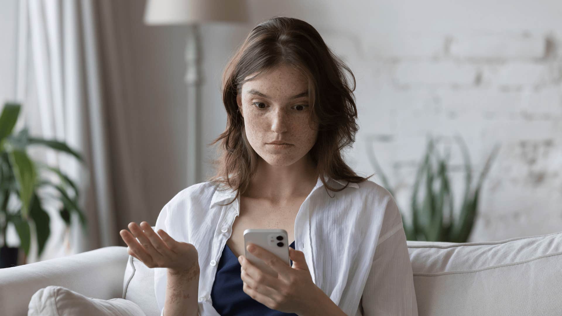upset woman looking at phone because man is hardly available