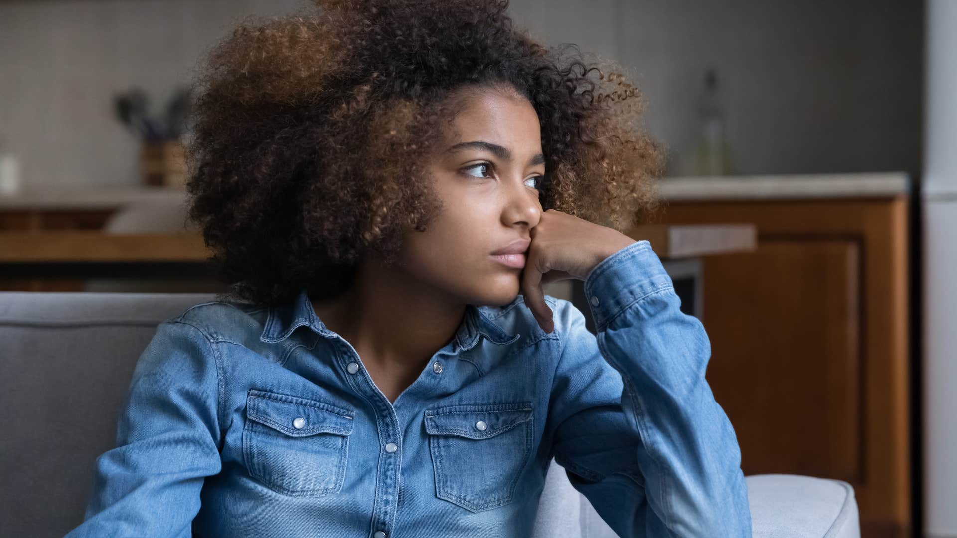 woman battling loneliness looking out a window