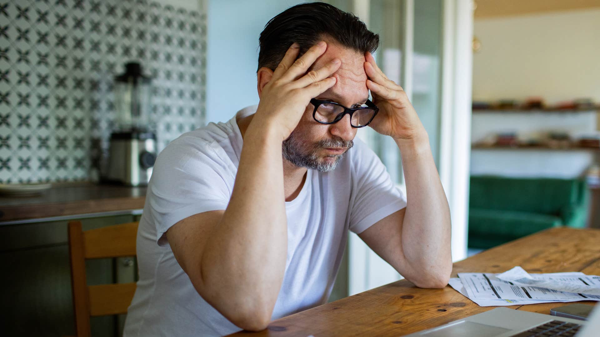 man feeling stagnant and stuck holding his head in his hands