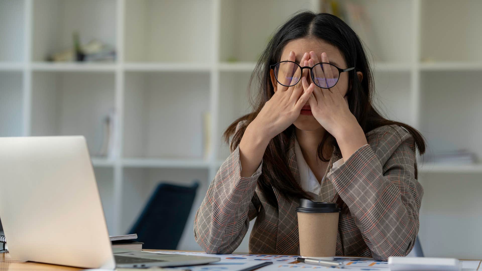 Go-to person at work holding her head in her hands.