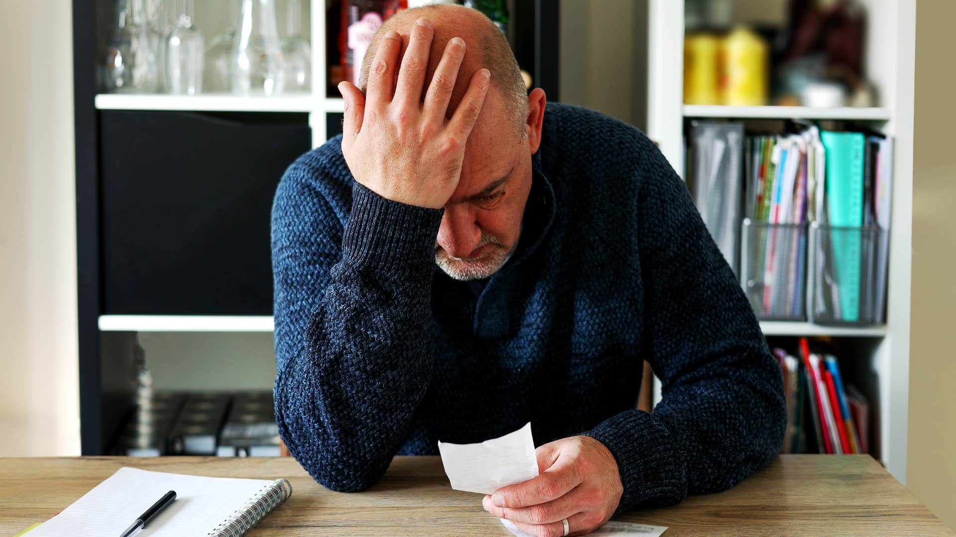 Stressed man doing bills and making ends meet on a low salary.