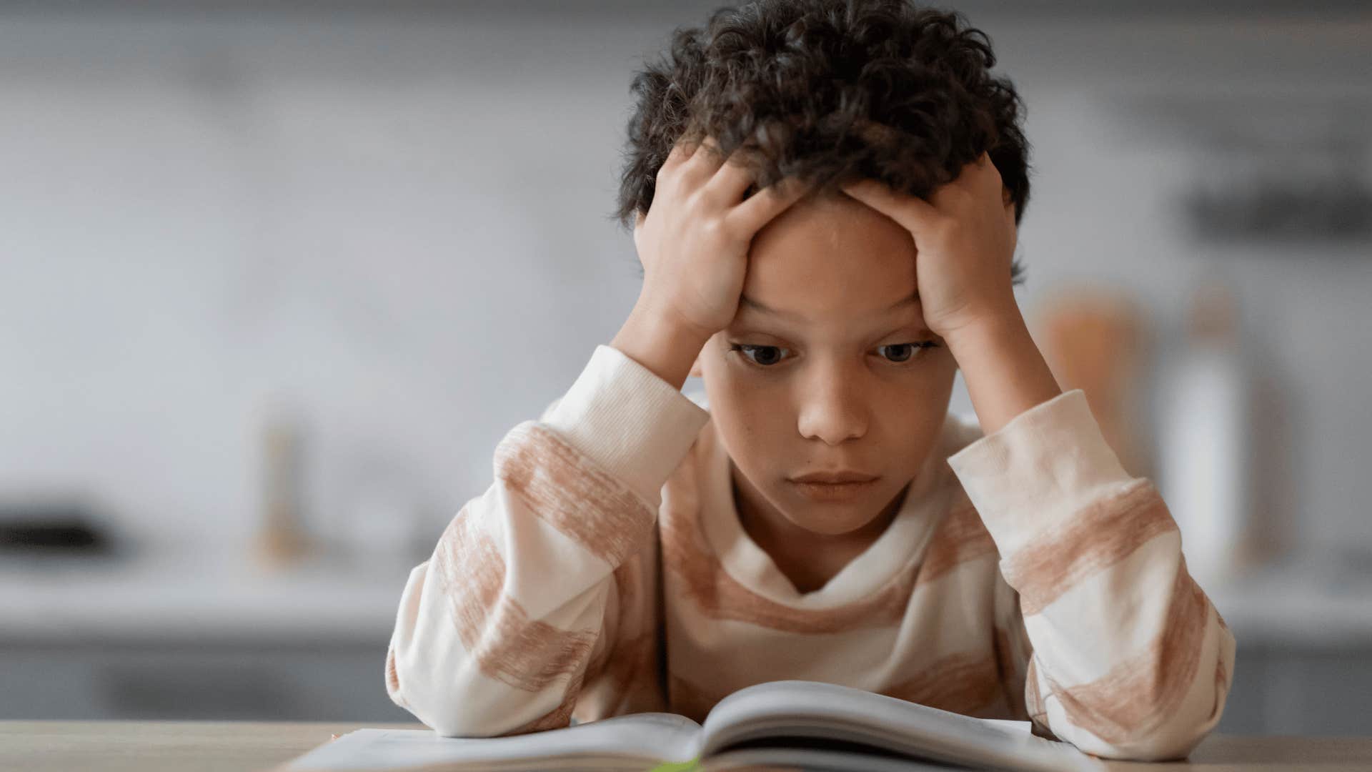 Upset young boy doing homework, even when he didn't want to.