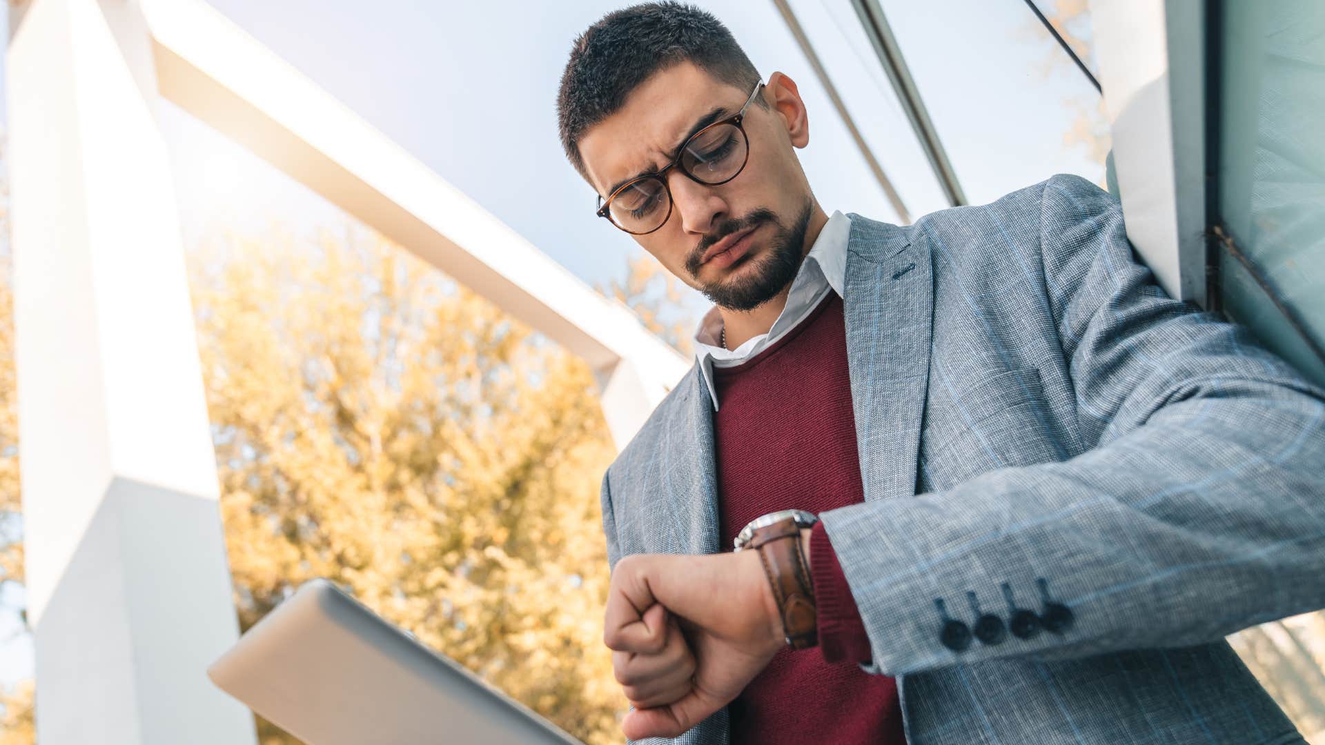 Man checking his watch and thinking about how a healthy routine is a busy one.