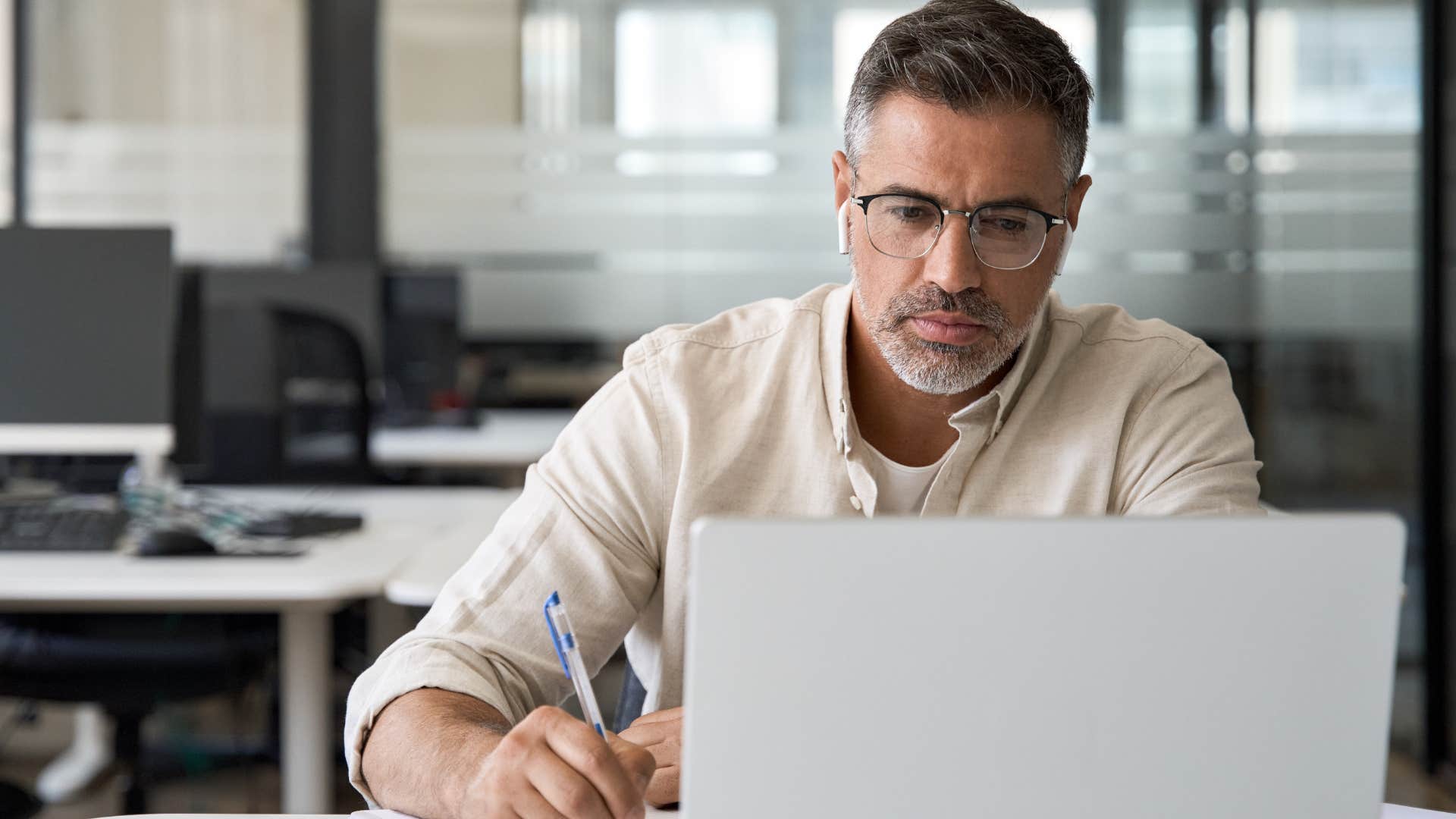 Serious man who believes independence is all about doing things yourself working on his laptop.