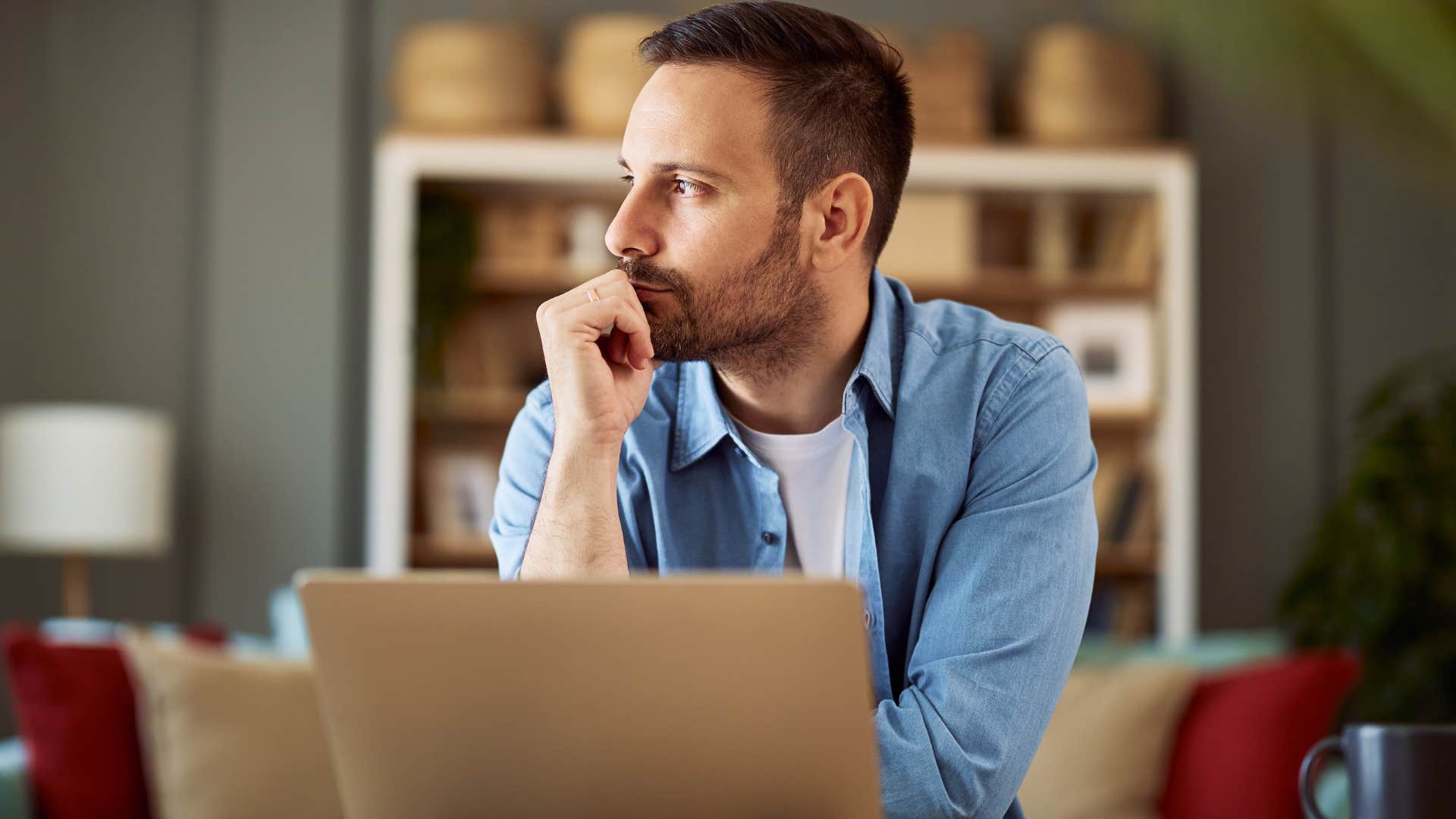 Man with logic and critical thinking looking away from his laptop.
