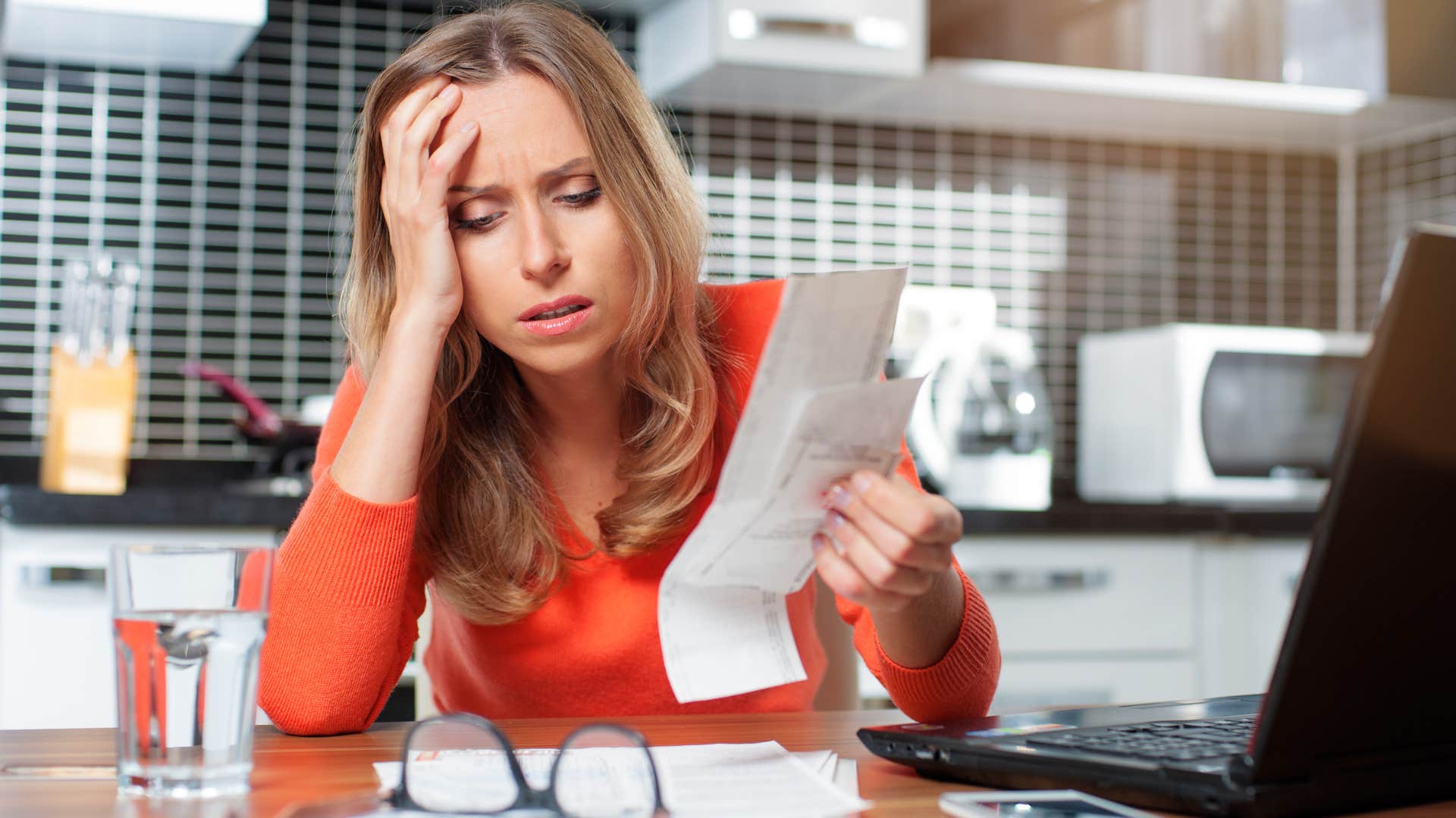 Woman who believes you have to sacrifice to be successful doing bills. 