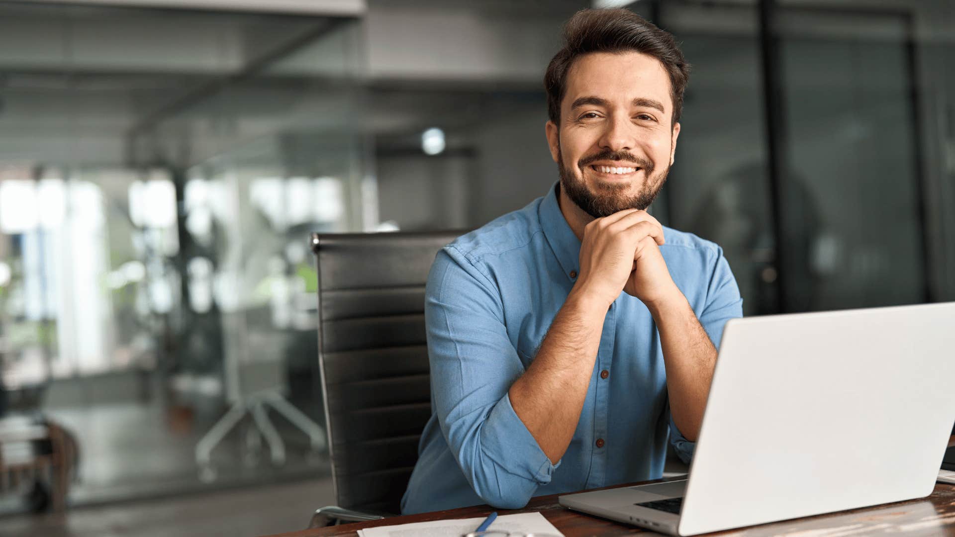 man relaxing and smiling at the camera as he limits multi-tasking