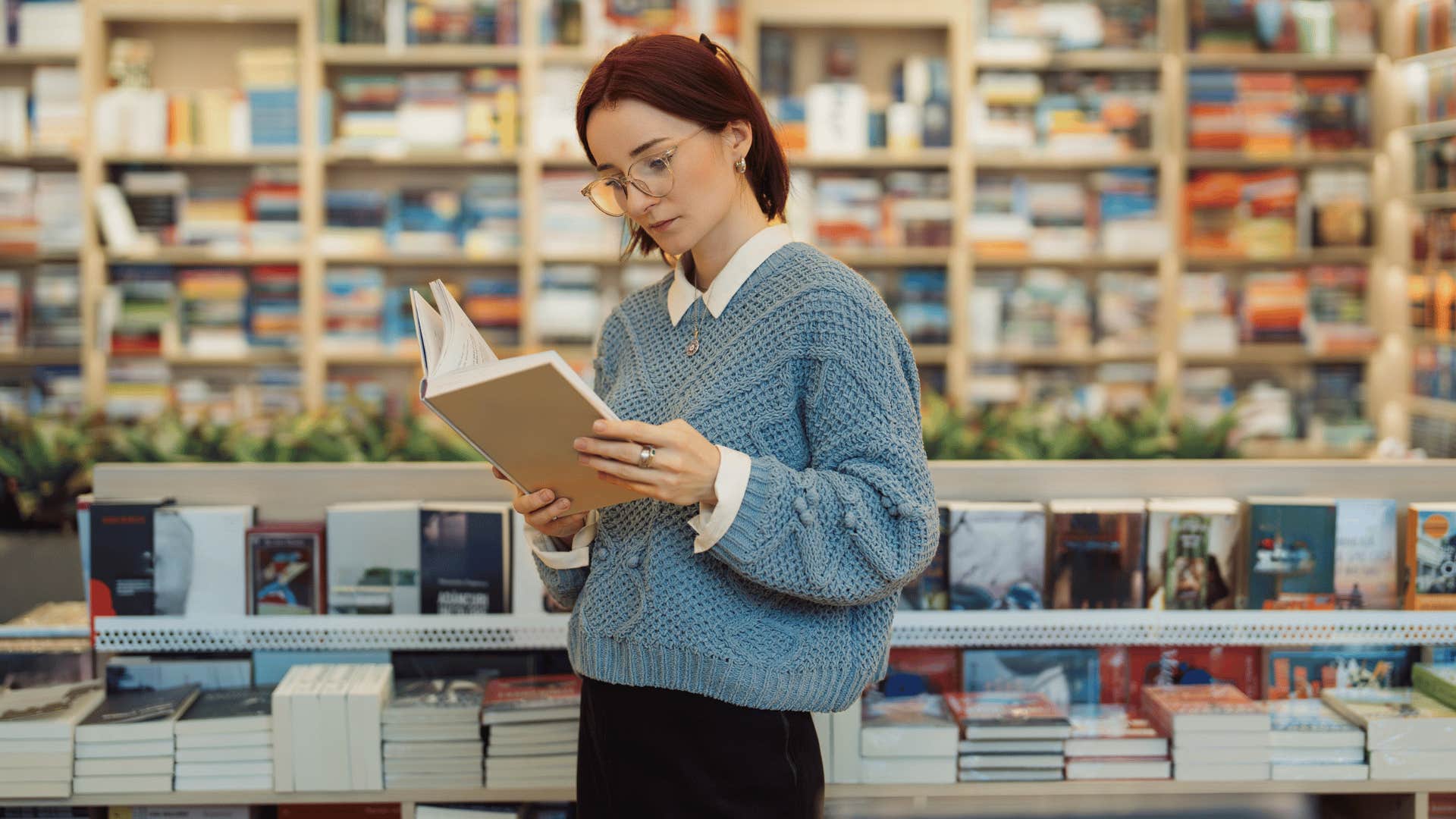woman in blue shirt limiting social media consumption by reading a book