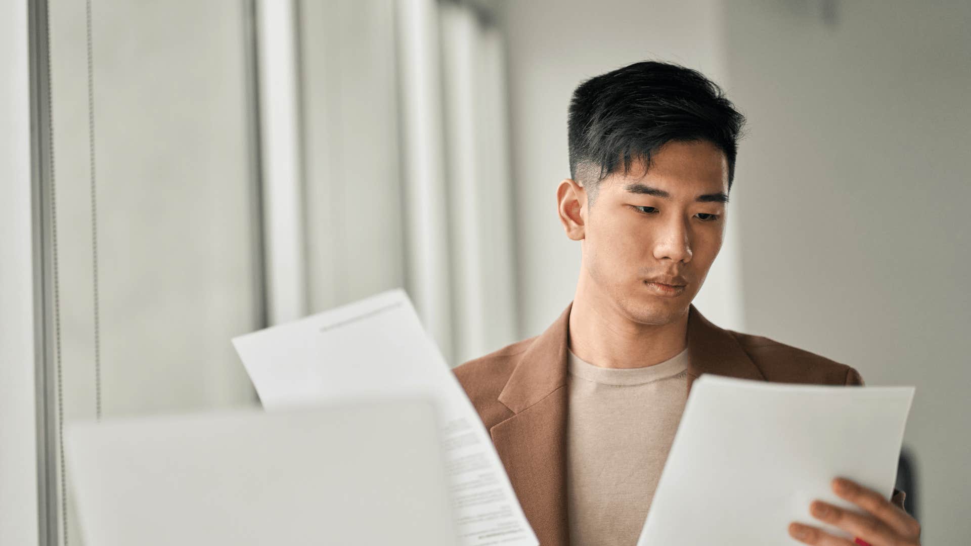 man looking at tax forms who knows millennial money hacks