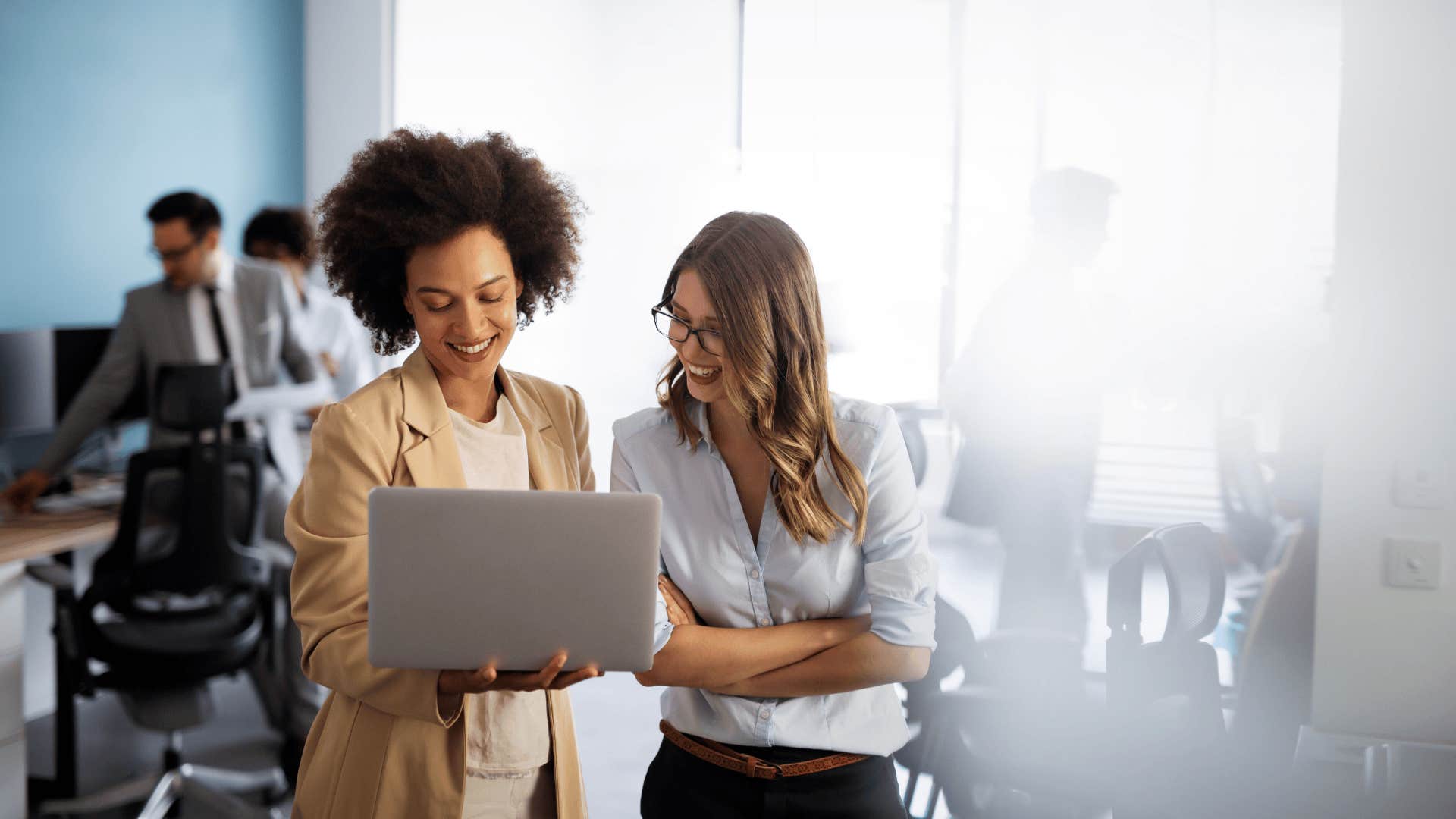woman with laptop who knows millennial money hacks explaining something to woman