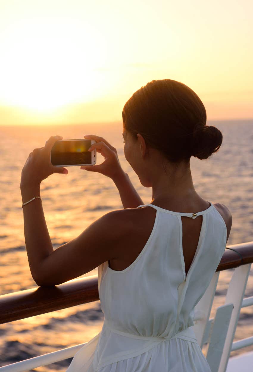 Millennial woman taking a photo with her phone horizontally gives away her age