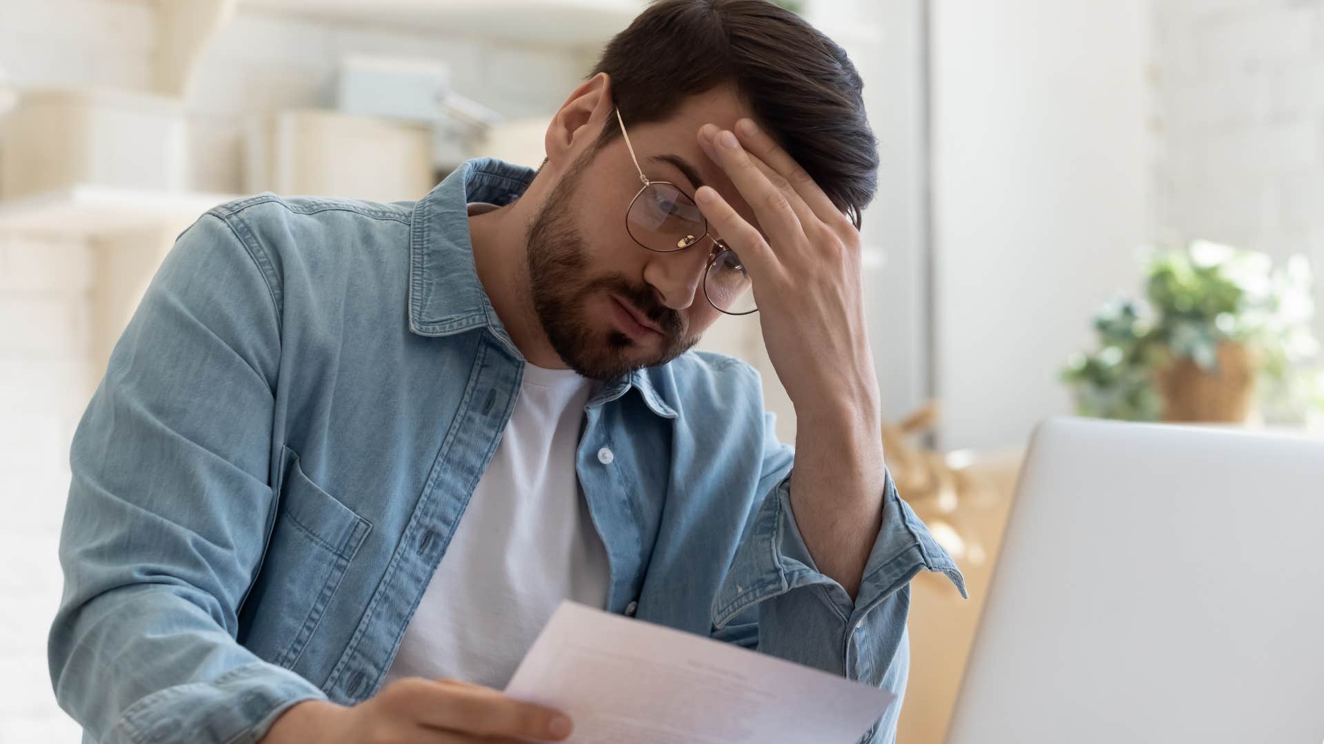 stressed underpaid man looking at bills