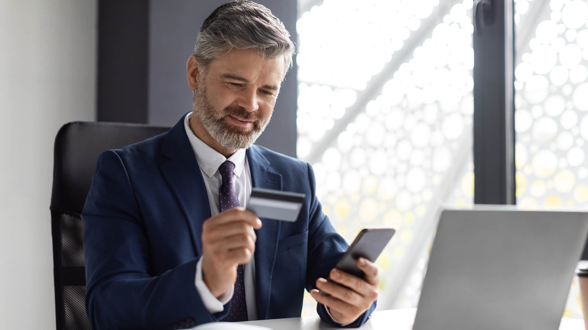 Man refusing to use Apple Pay with a physical card at his desk.