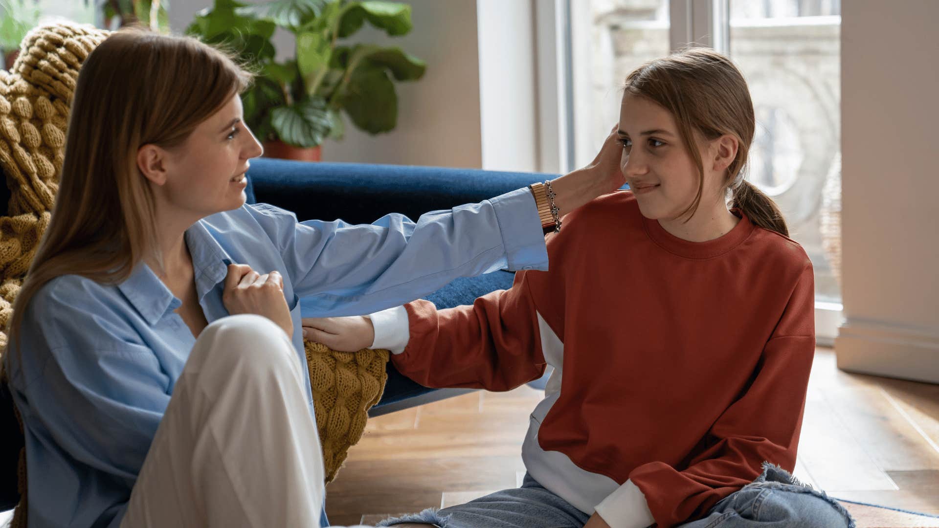 mom holding her daughters cheek and pushing her ego to the side to apologize 