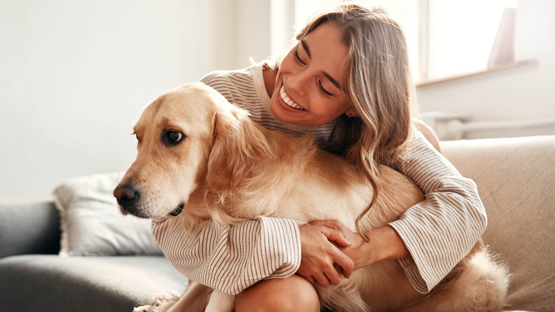 A woman says bless you to her dog after he sneezed