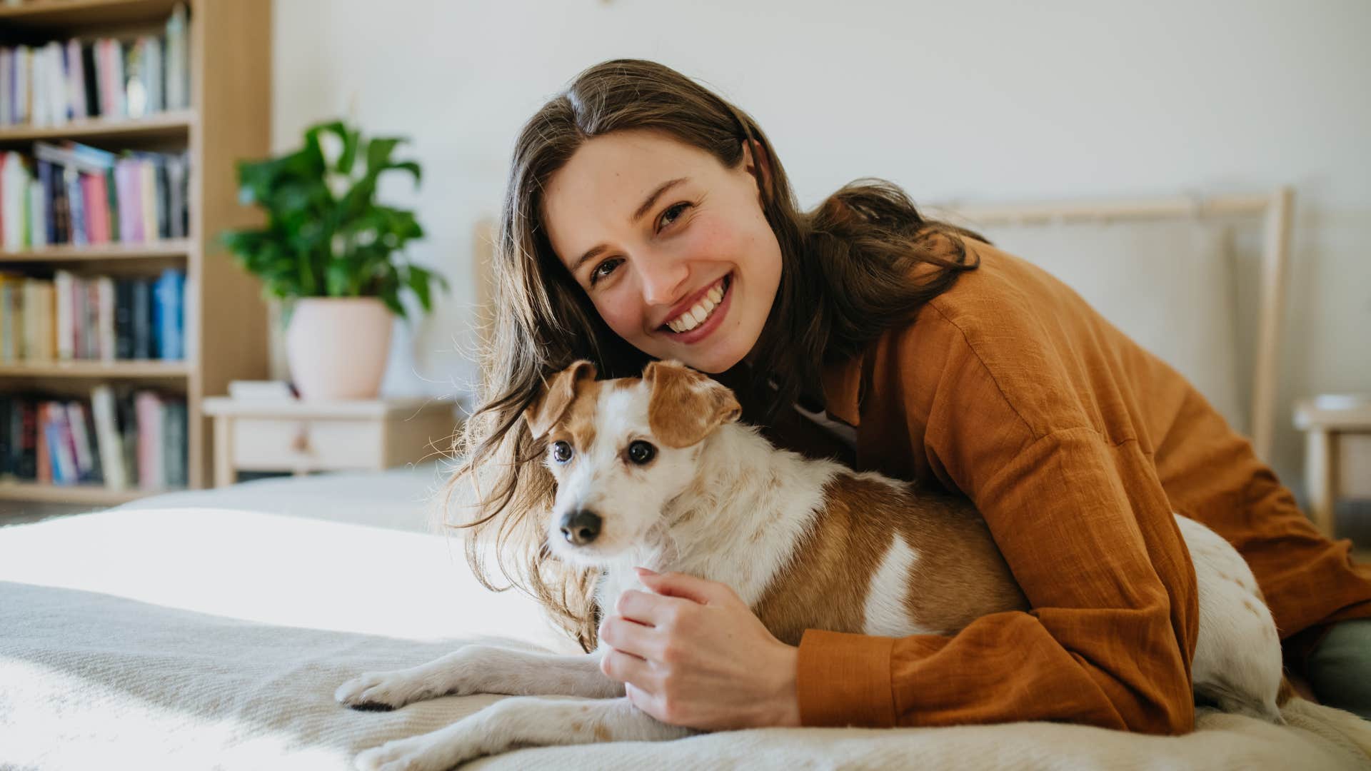 A woman lets her dog sleep in her bed to make him more comfortable