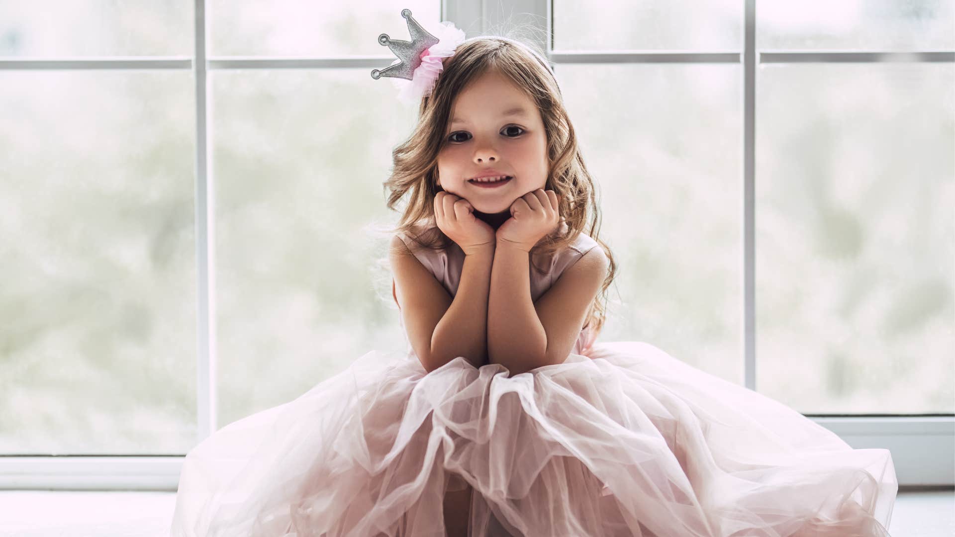 young girl wearing a crown and princess dress