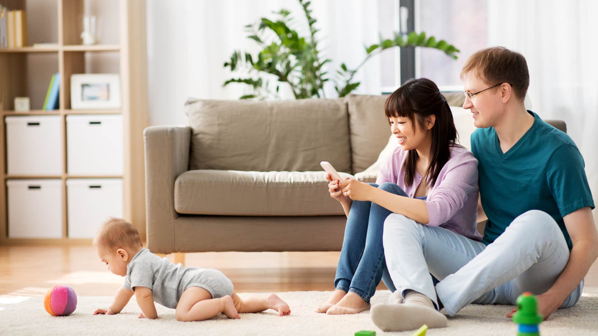couple watching their son crawl around