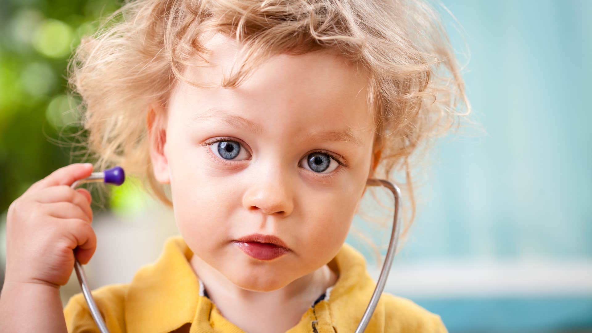 little boy wearing stethoscope playing pretend