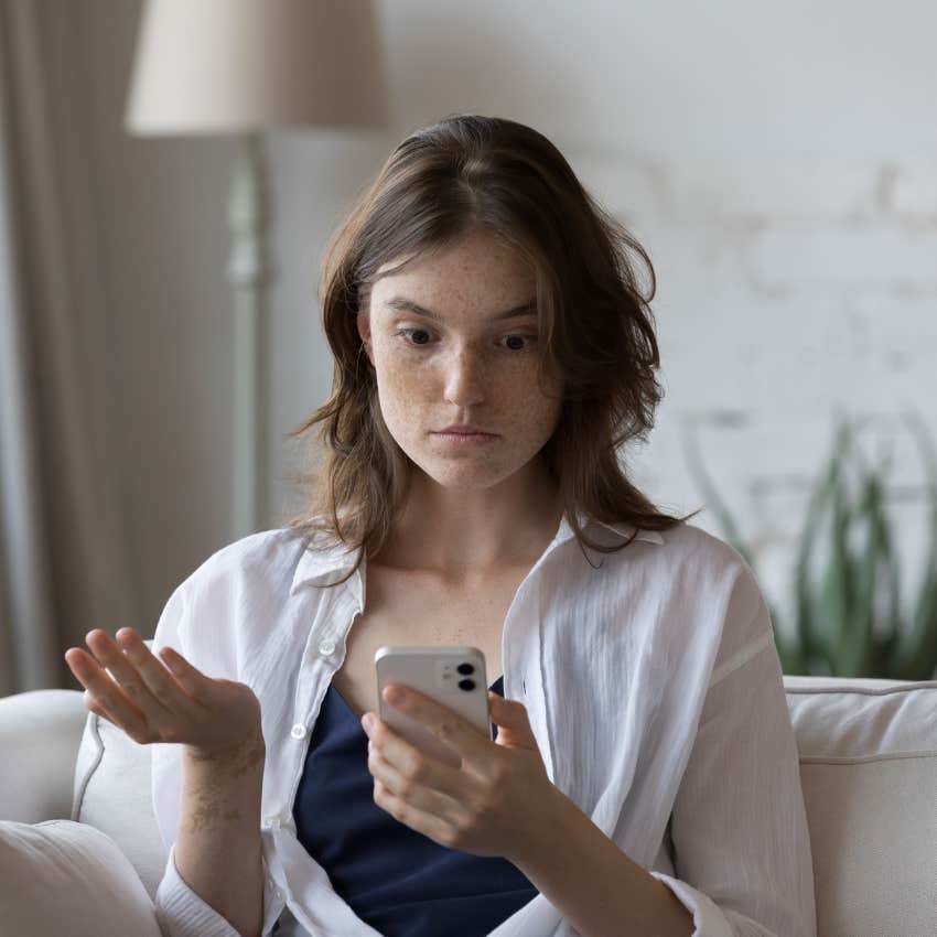 upset woman looking at phone to see if he sees her worth
