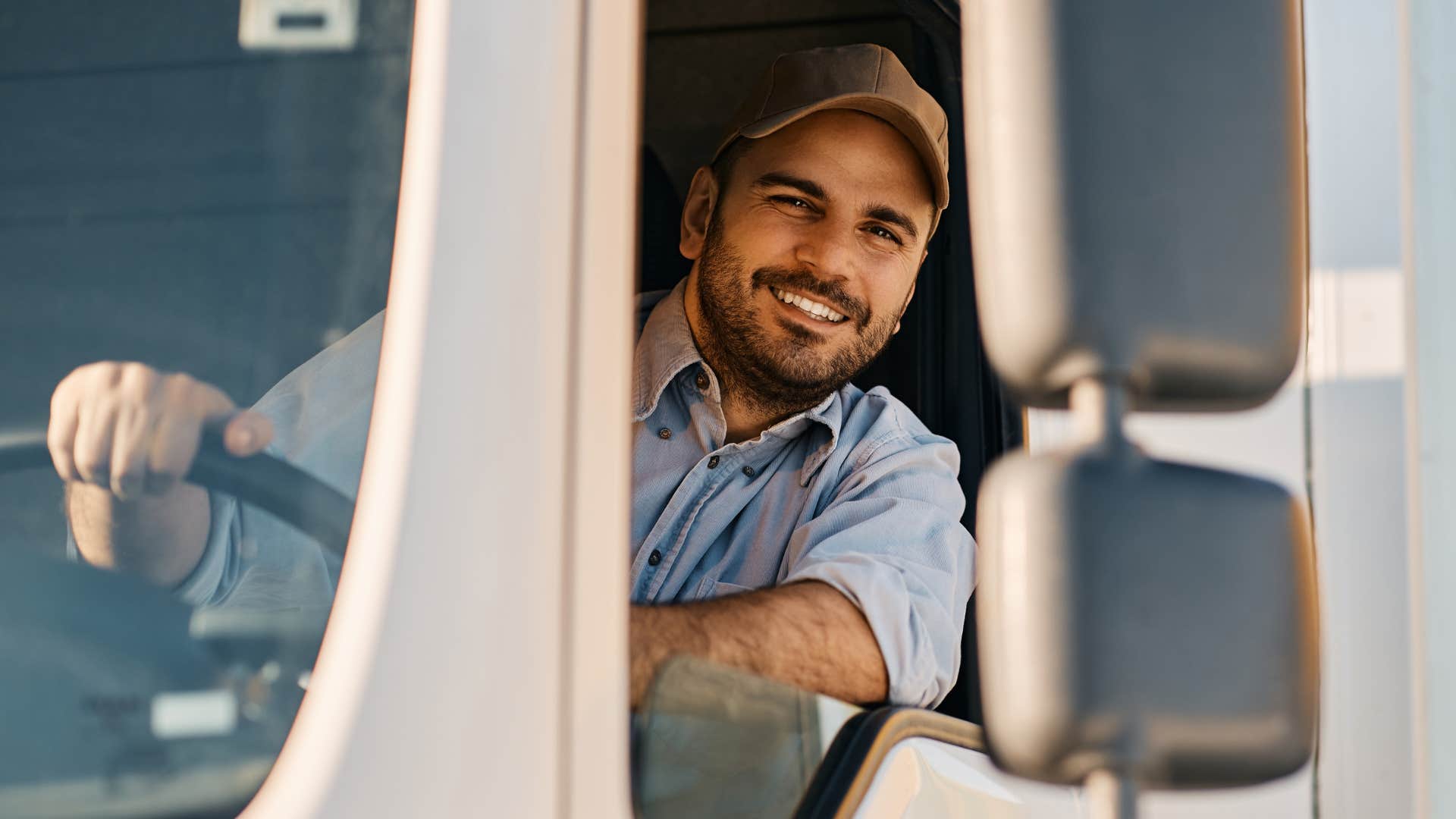 Truck driver smiling in his truck.