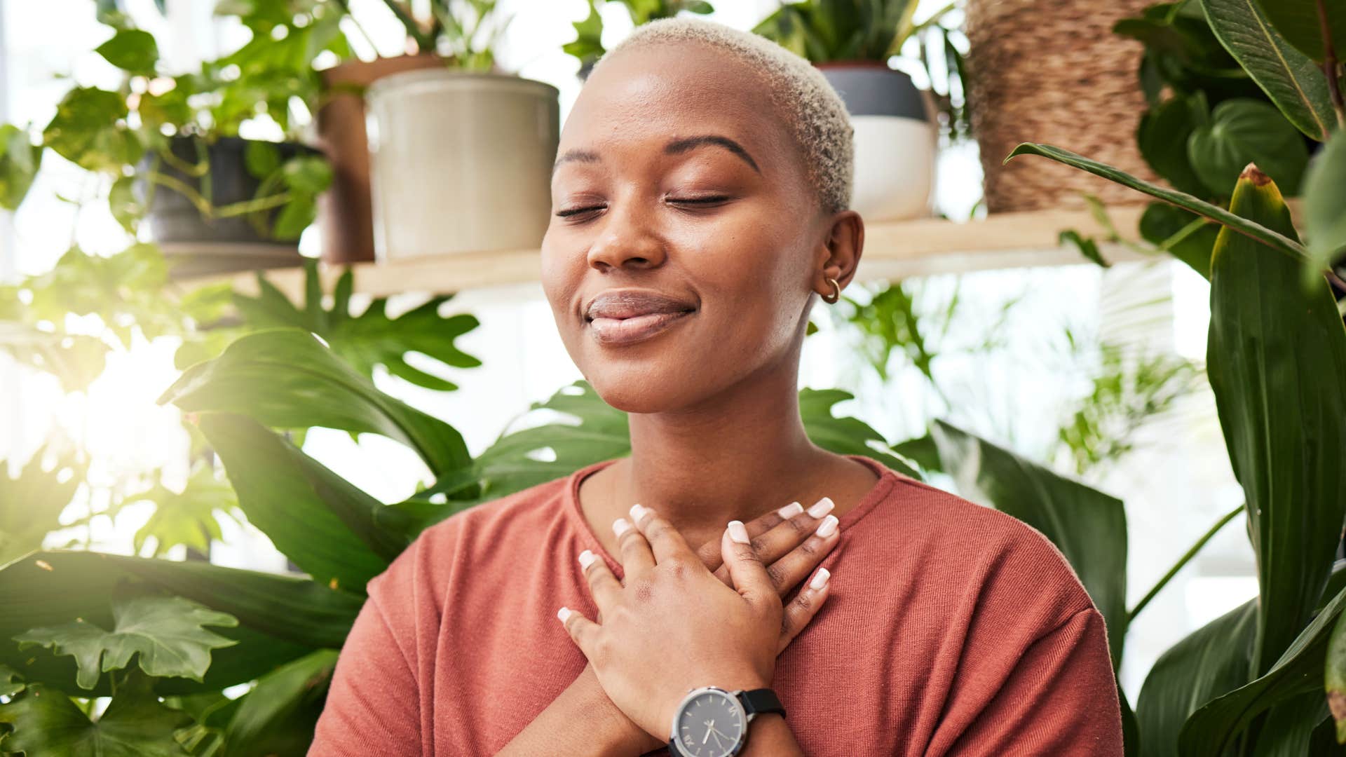 woman in red shirt who values her peace is meditating and putting hand over chest
