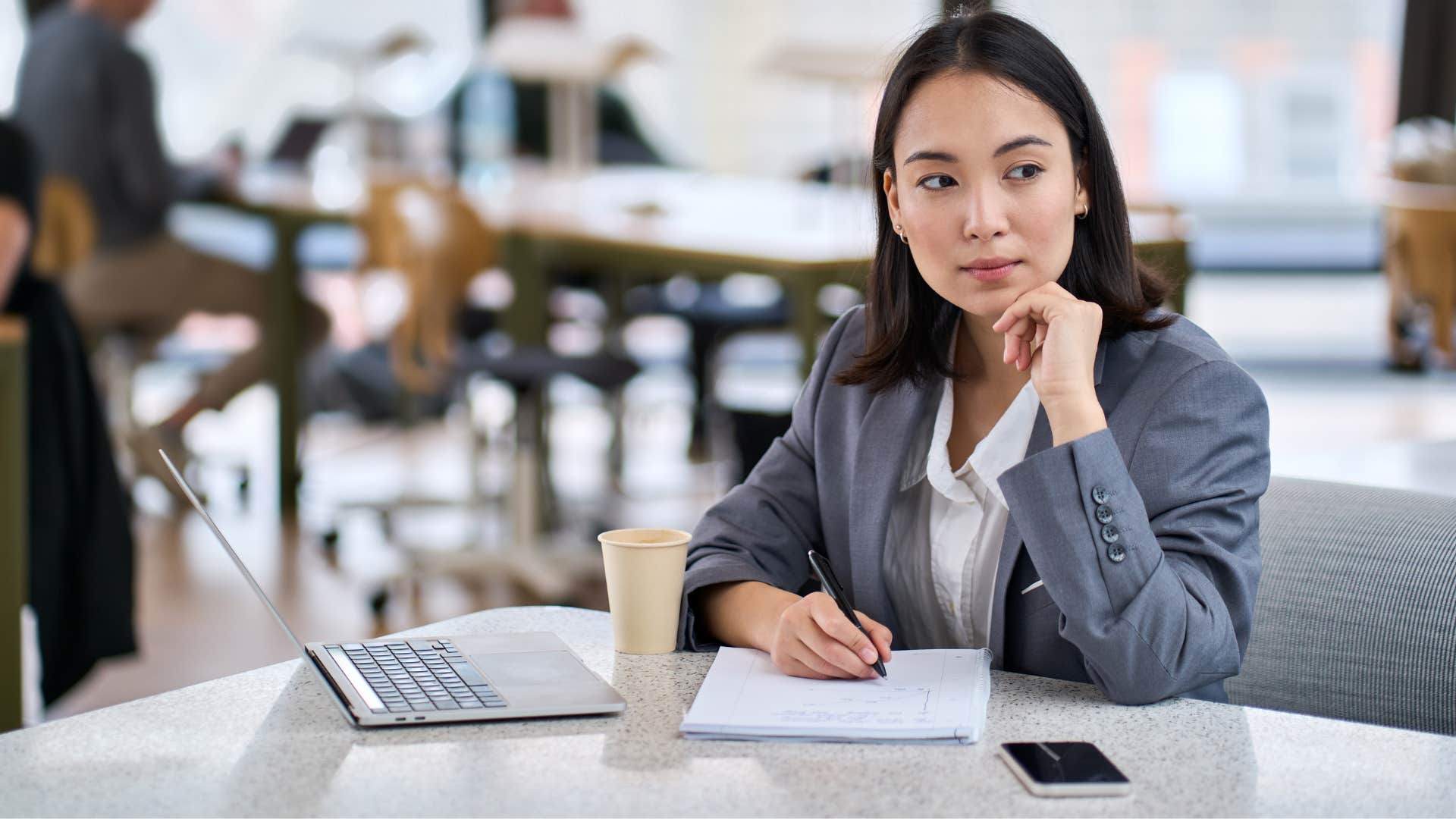 woman whose figuring out life looking to the side as she writes down notes