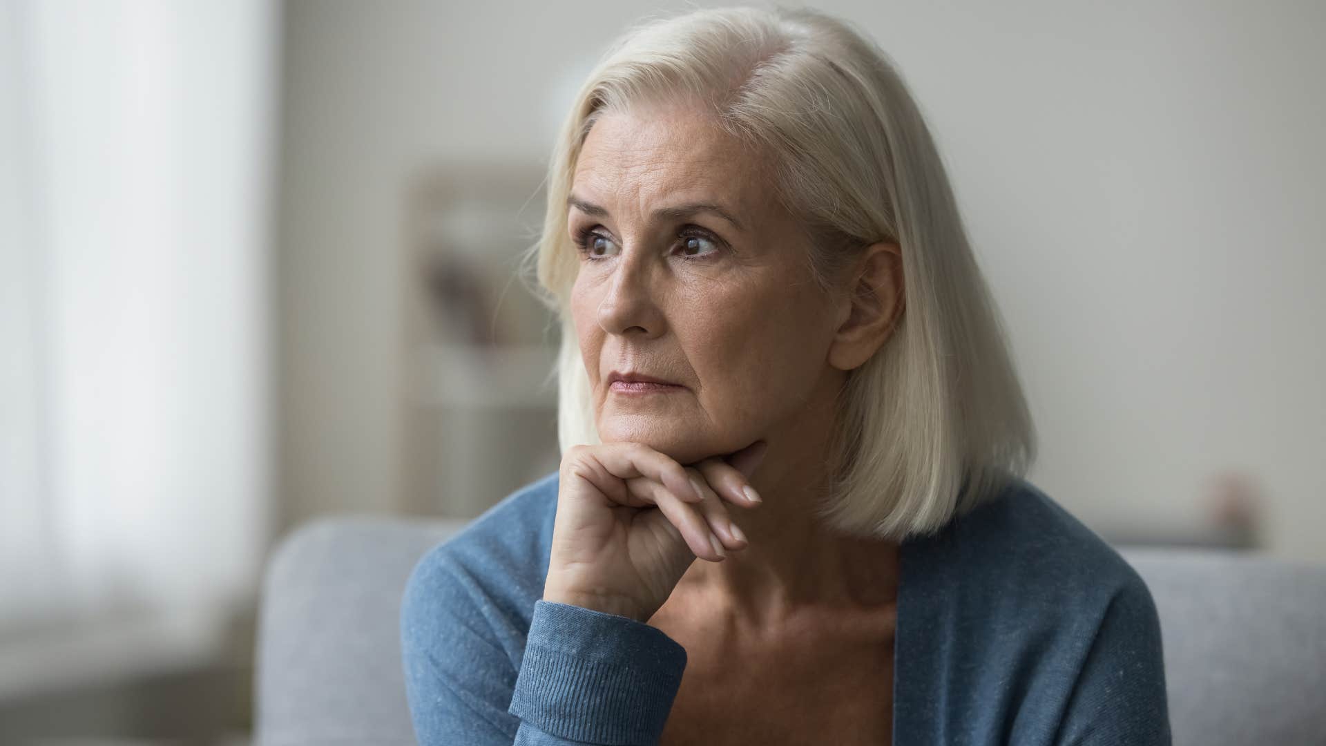 woman whose struggling with guilt looking to her side while propping chin in hand