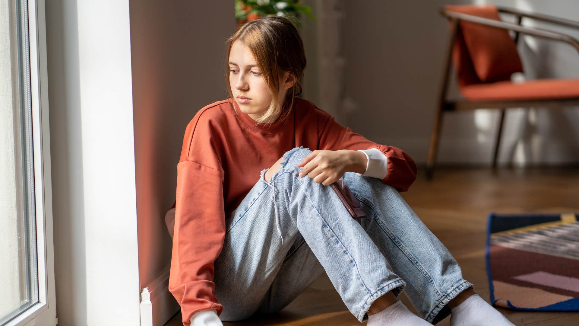 stressed out and anxious young woman sitting on the floor