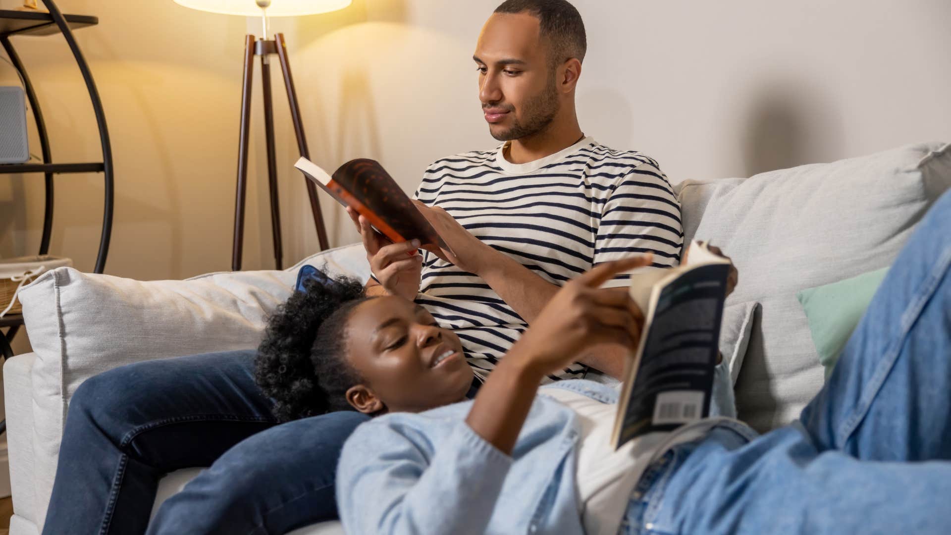 couple recovering from socializing reading together on couch