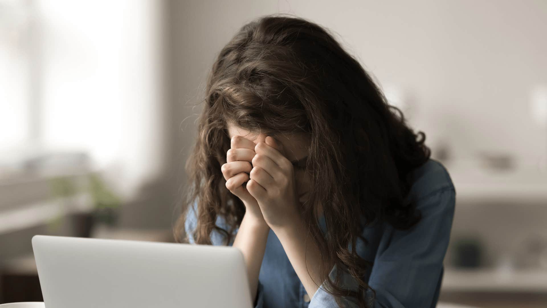upset woman at computer who was raised by emotionally immature parents