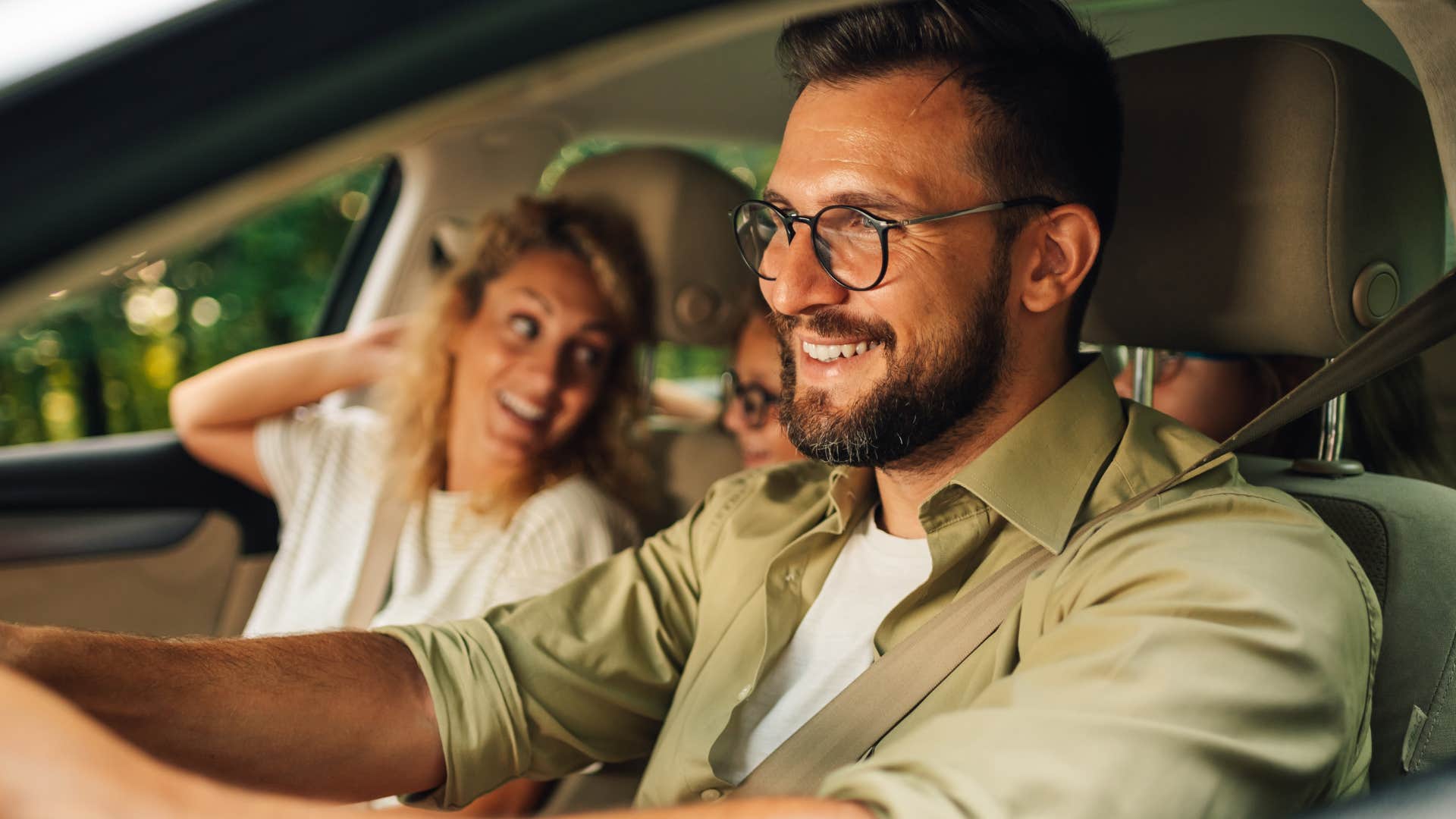 Man who feels empowered to live their own personal life smiling in the car with his family.