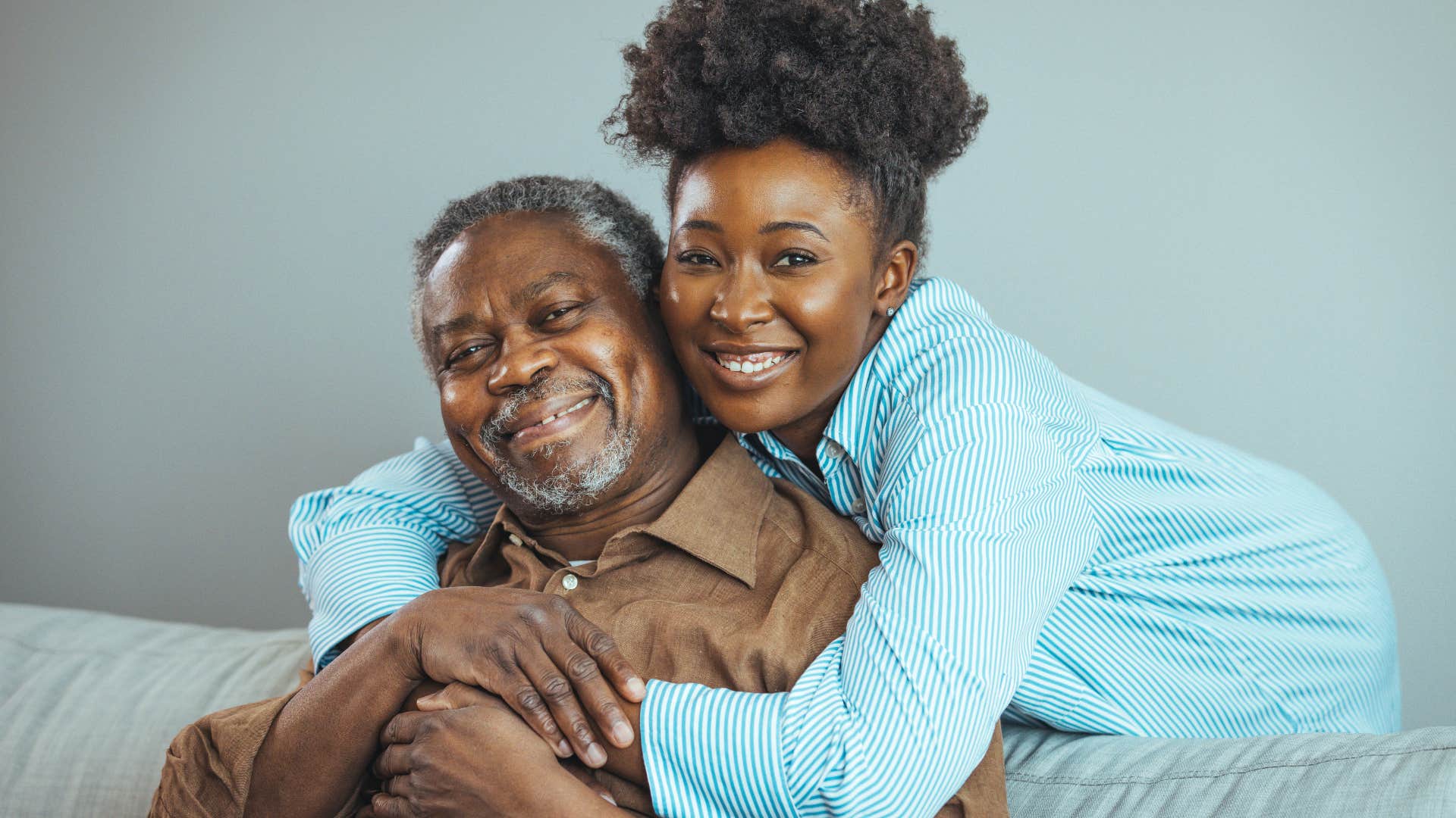 Woman hugging her father at home where's there's not a strong power dynamic. 