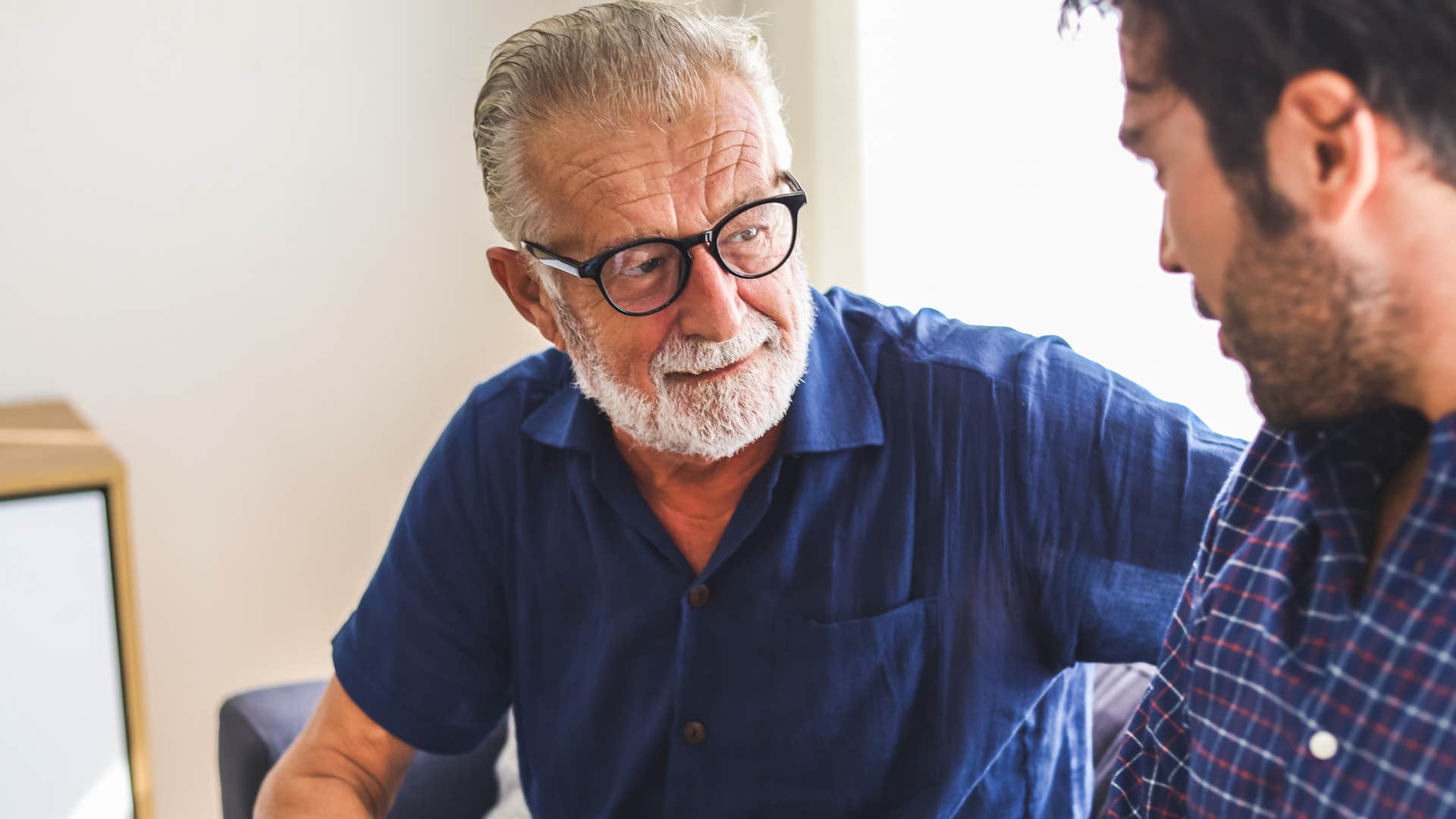 Dad who can talk about childhood adversity openly looking at his adult son. 
