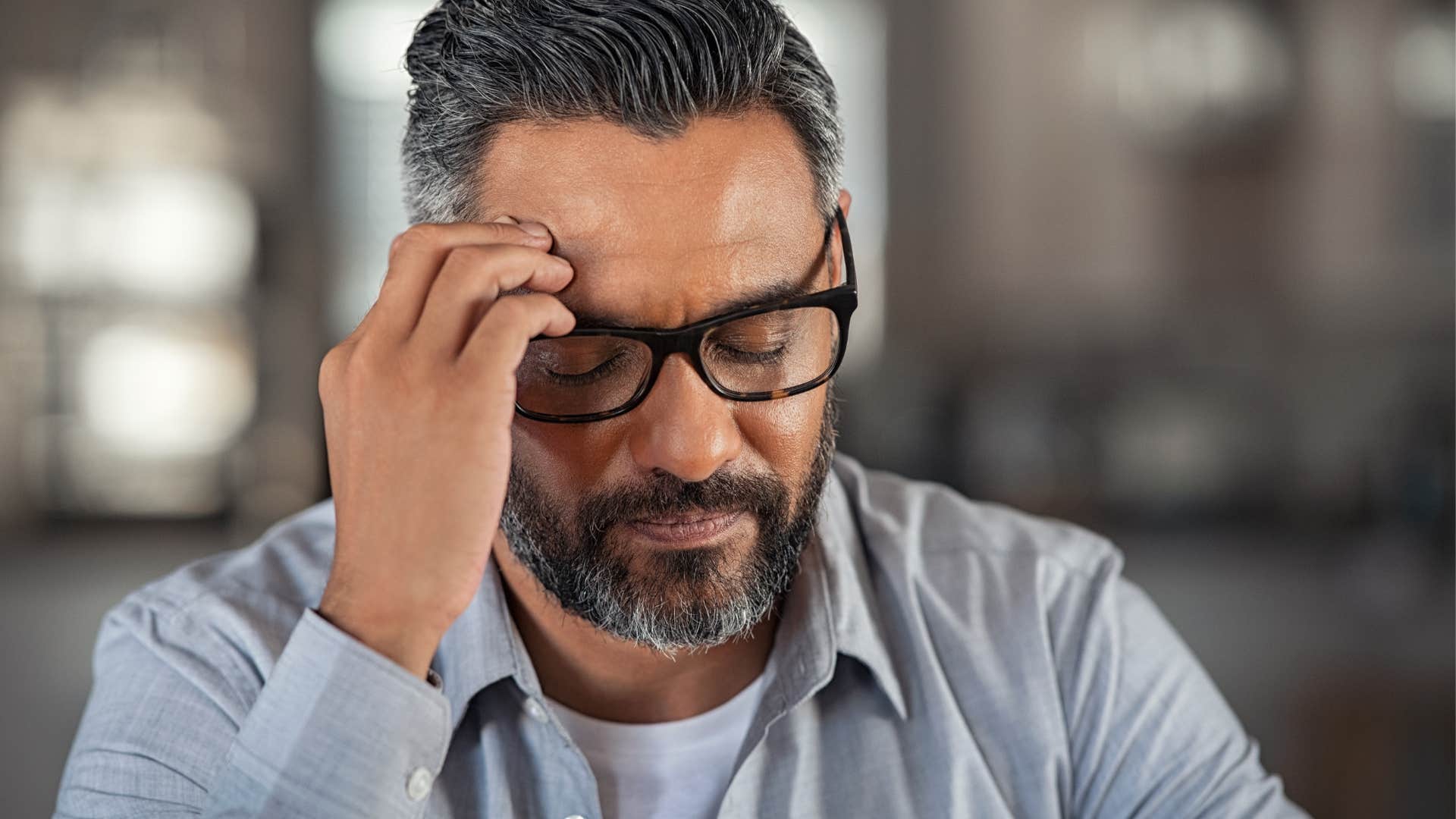 depressed man holding his head in pain