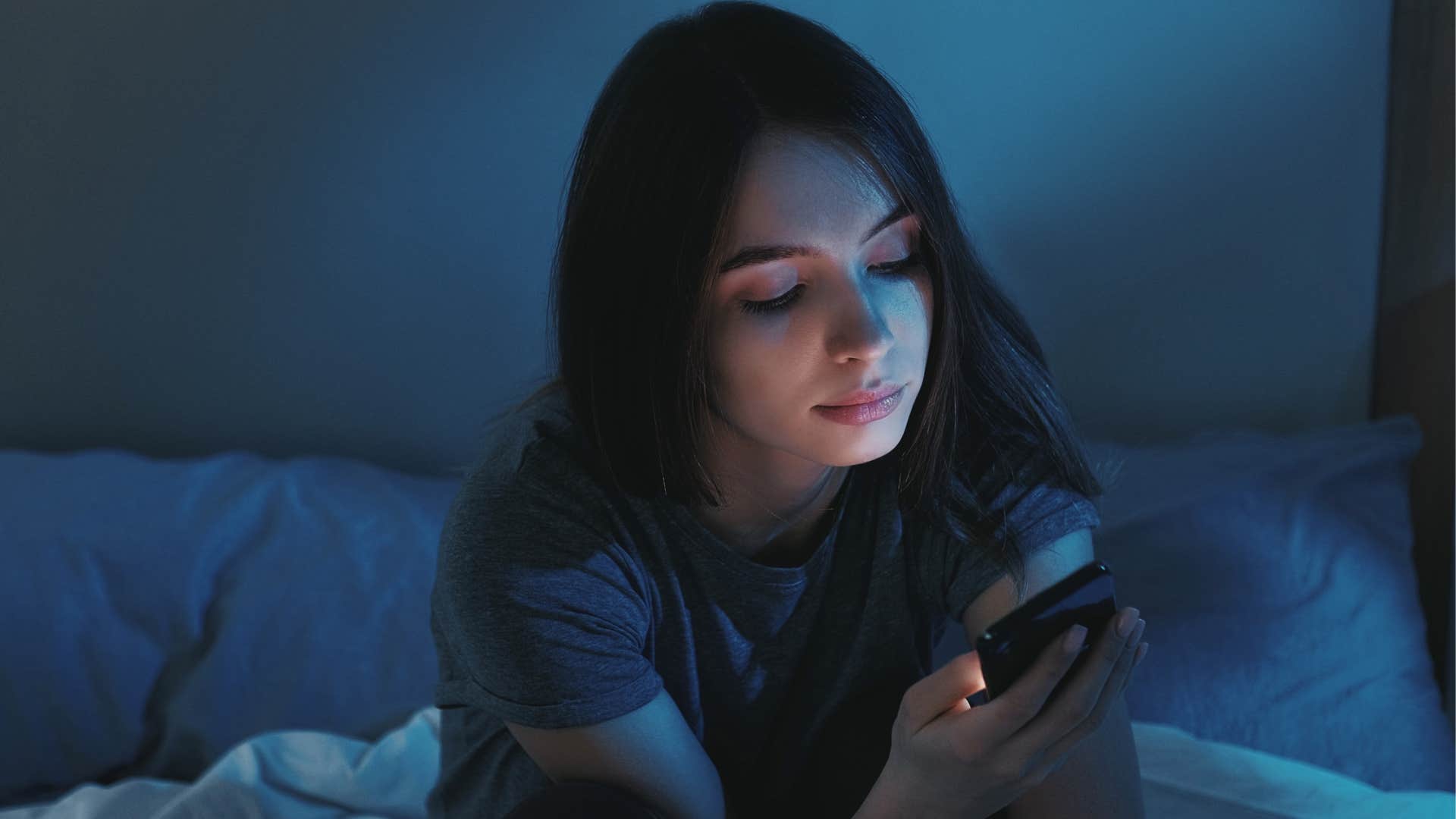 woman doomscrolling on her phone in the dark