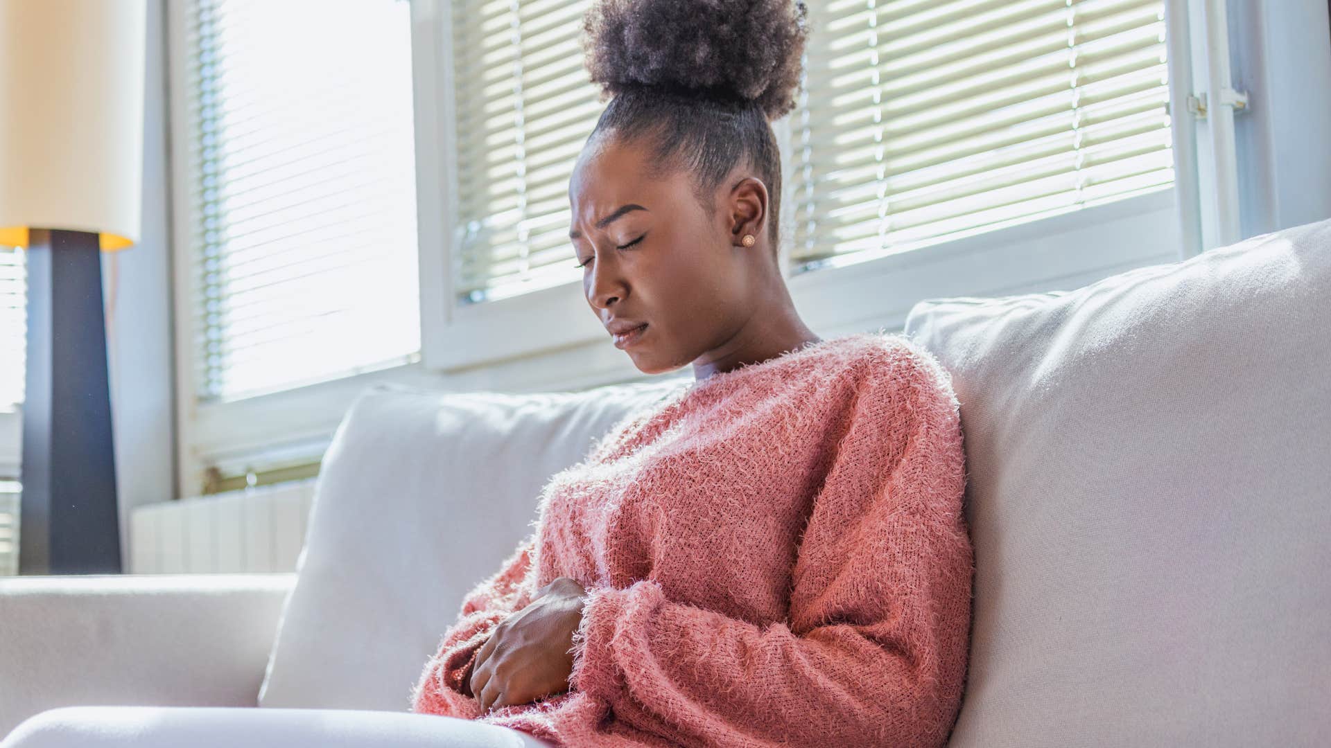 woman with hormonal imbalances holding her stomach