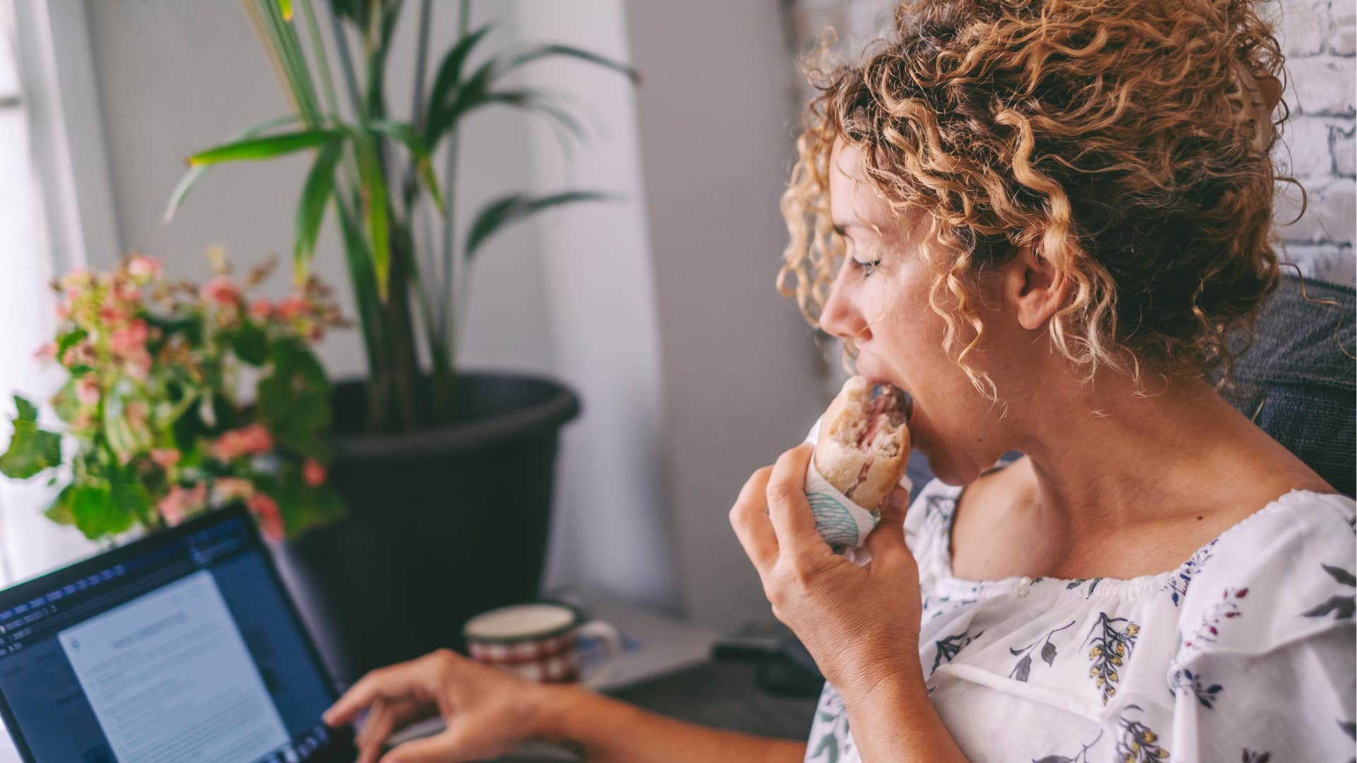 woman with a poor diet eating fast food at her desk