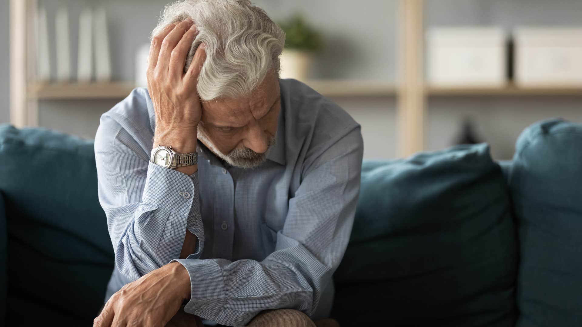 isolated man who doesn't live close to friends or family holding his head