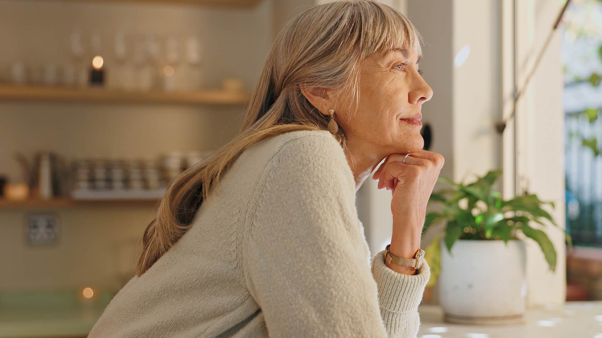 peaceful woman smiling contently looking out the window