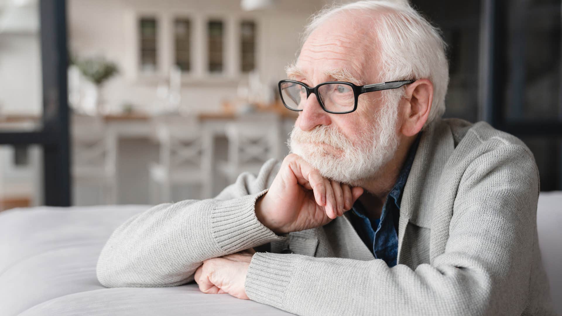 lonely man battling unresolved trauma looking out a window