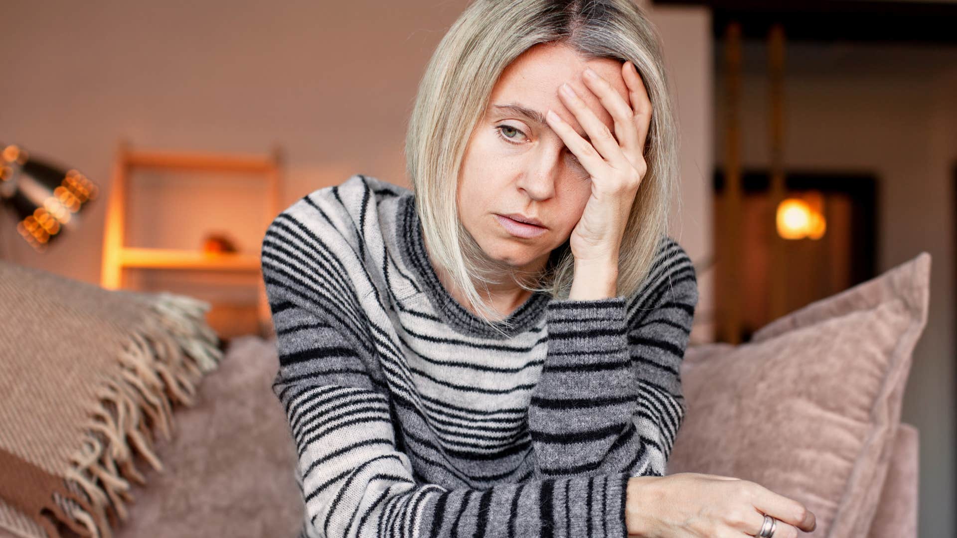 Emotionally vulnerable woman holding her head in her hands.
