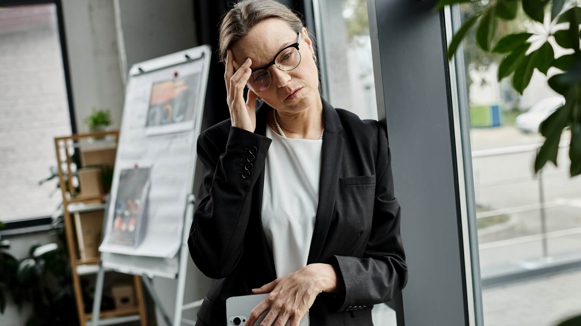 Stubborn woman holding her head in an office.