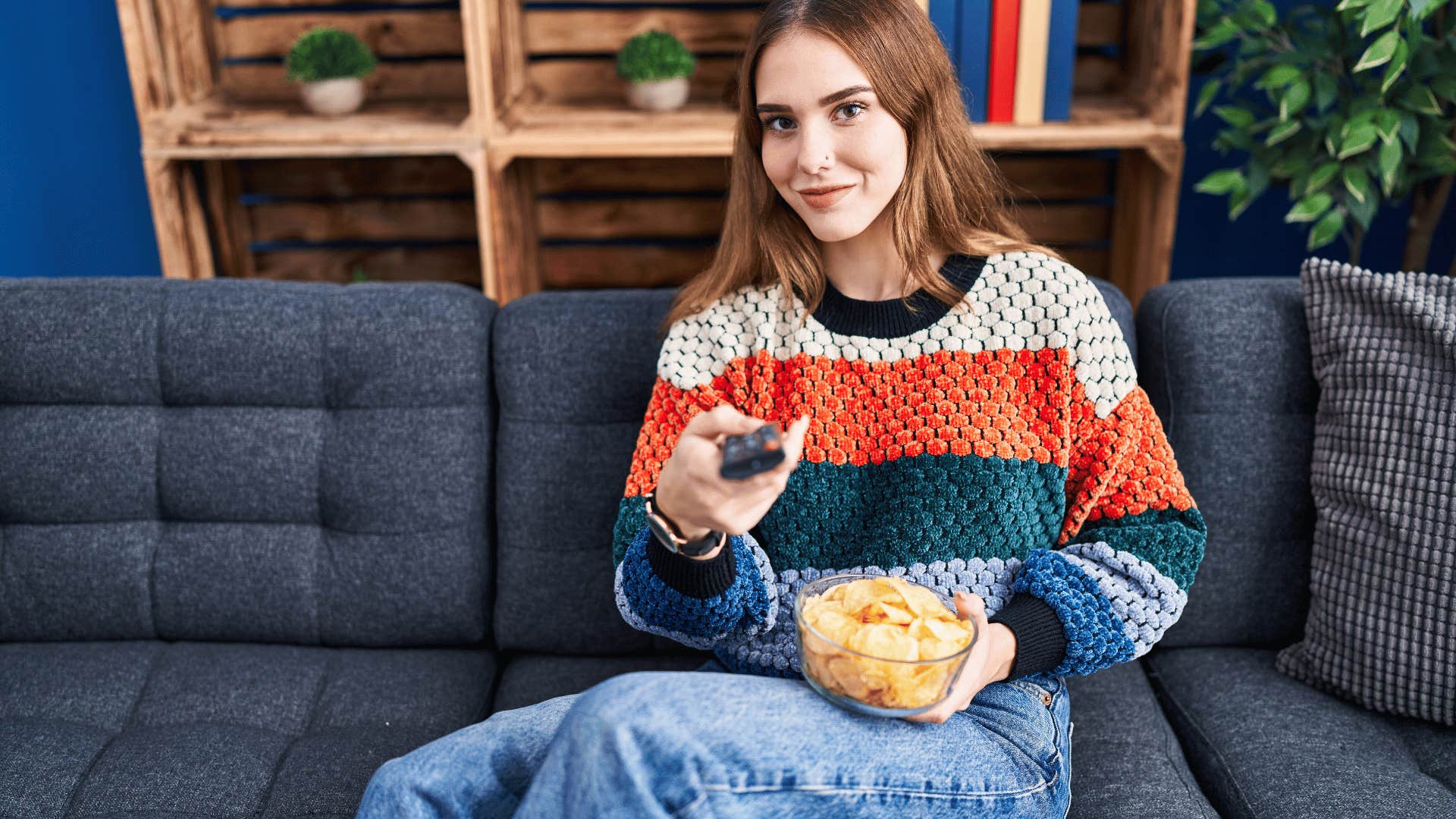 woman sitting on the couch binge-watching tv